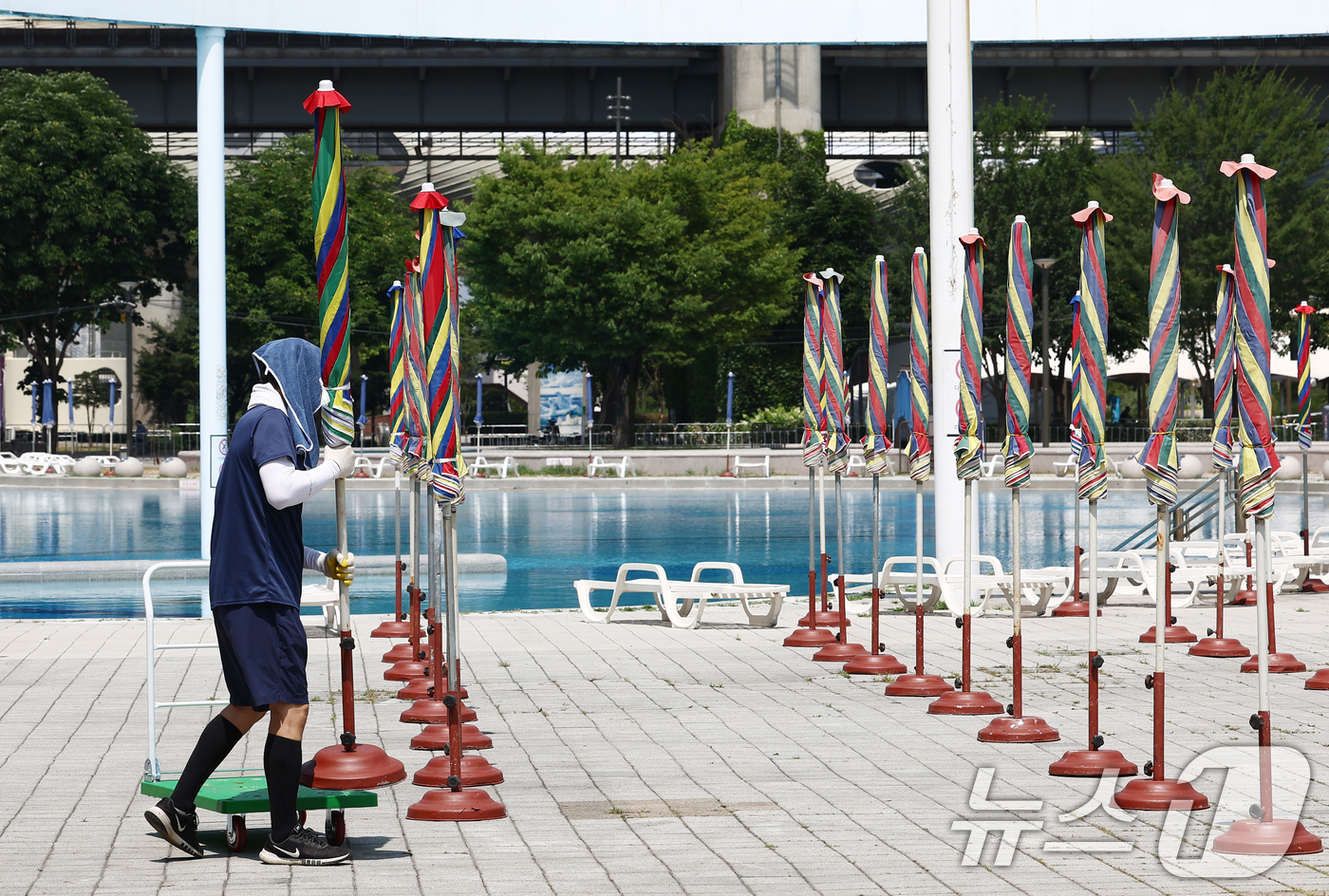 (서울=뉴스1) 김민지 기자 = 일년 중 낮의 길이가 가장 길고 밤의 길이가 가장 짧다는 절기 '하지(夏至)'를 앞둔 18일 서울 성동구 뚝섬 한강공원 수영장에서 관계자들이 개장을 …