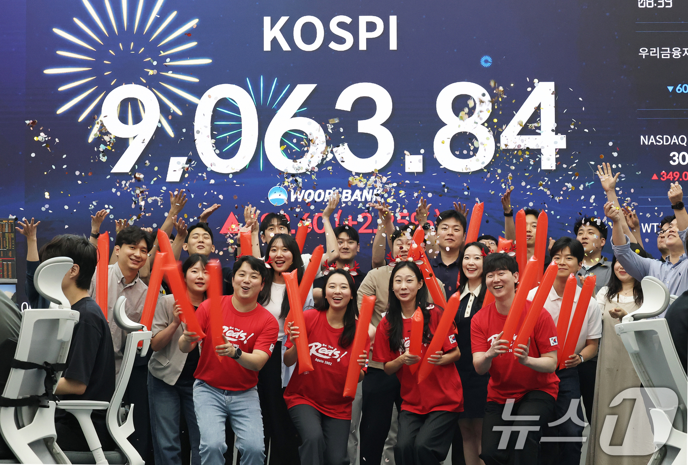 (서울=뉴스1) 오대일 기자 = 코스피 지수가 전인미답의 9000선 고지를 돌파한 18일 오후 서울 중구 우리은행 본점 딜링룸에서 직원들이 코스피 종가를 배경으로 축하 세리머니를 …