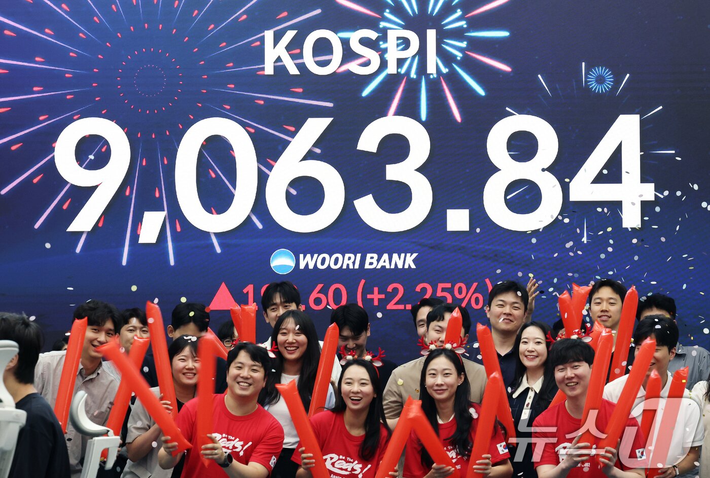 본문 이미지 - 코스피 지수가 전인미답의 9000선 고지를 돌파한 18일 오후 서울 중구 우리은행 본점 딜링룸에서 직원들이 코스피 종가를 배경으로 축하 세리머니를 하고 있다.  2026.6.18 ⓒ 뉴스1 오대일 기자