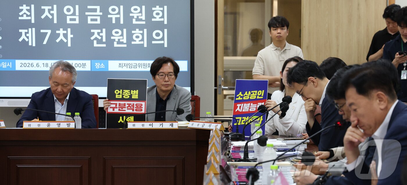 본문 이미지 - 18일 세종시 정부세종청사 최저임금위원회에서 열린 2027년도 최저임금위원회 7차 전원회의에 참석한 사용자위원들이 손팻말을 들고 발언을 듣고 있다. 2026.6.18 ⓒ 뉴스1 김기남 기자