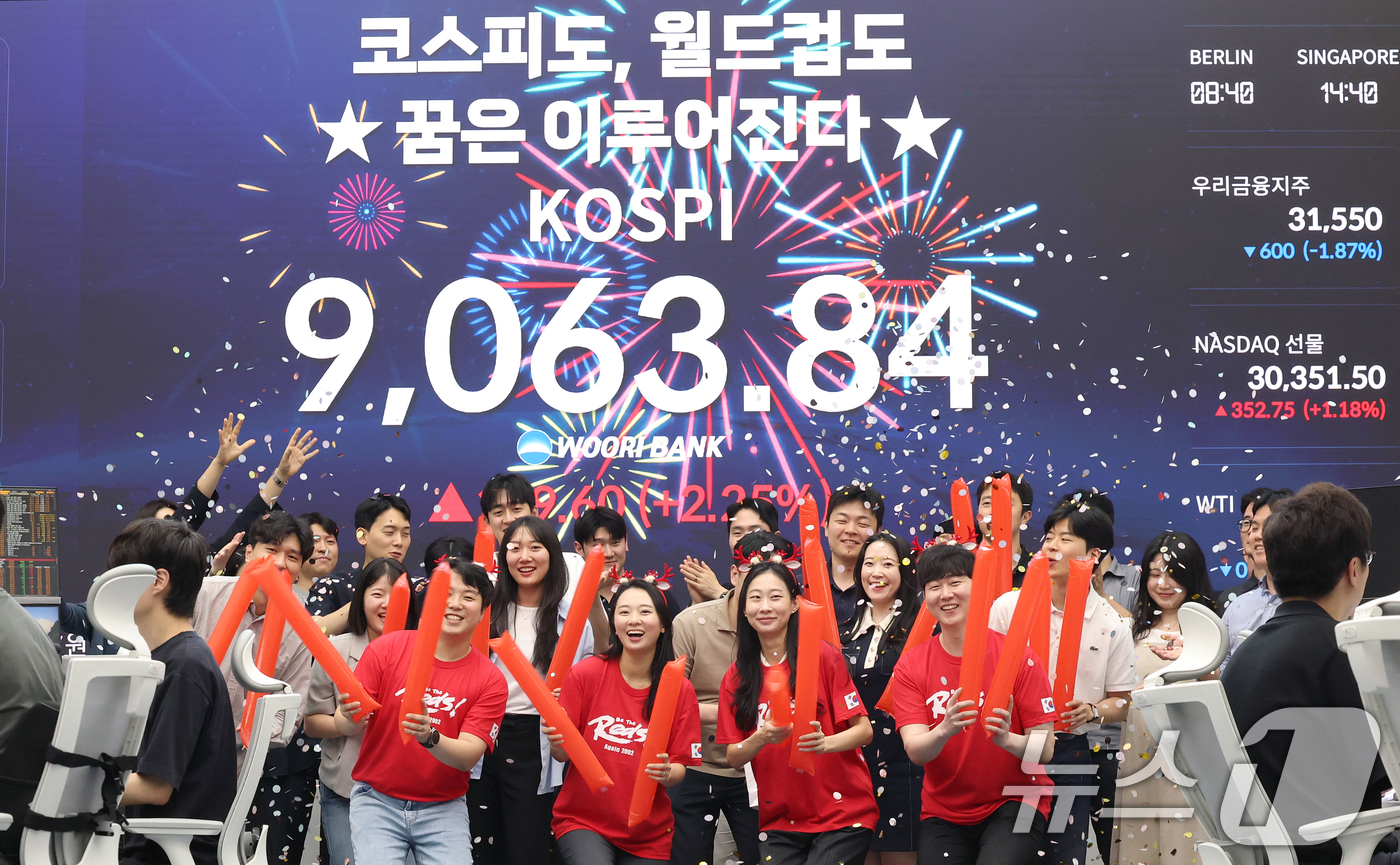 (서울=뉴스1) 오대일 기자 = 코스피 지수가 전인미답의 9000선 고지를 돌파한 18일 오후 서울 중구 우리은행 본점 딜링룸에서 직원들이 코스피 종가를 배경으로 축하 세리머니를 …