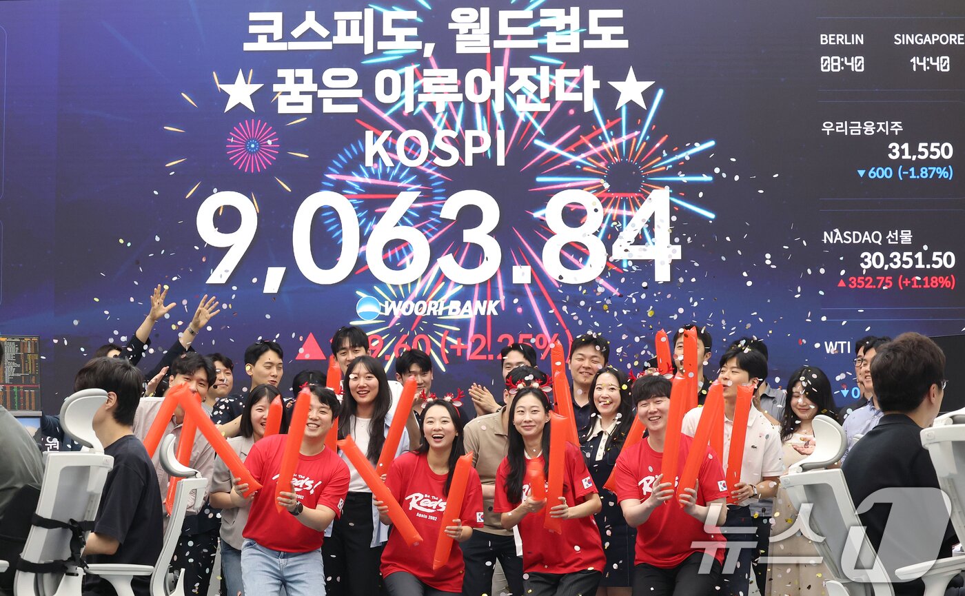 본문 이미지 - 코스피 지수가 전인미답의 9000선 고지를 돌파한 18일 오후 서울 중구 우리은행 본점 딜링룸에서 직원들이 코스피 종가를 배경으로 축하 세리머니를 하고 있다.  ⓒ 뉴스1 오대일 기자