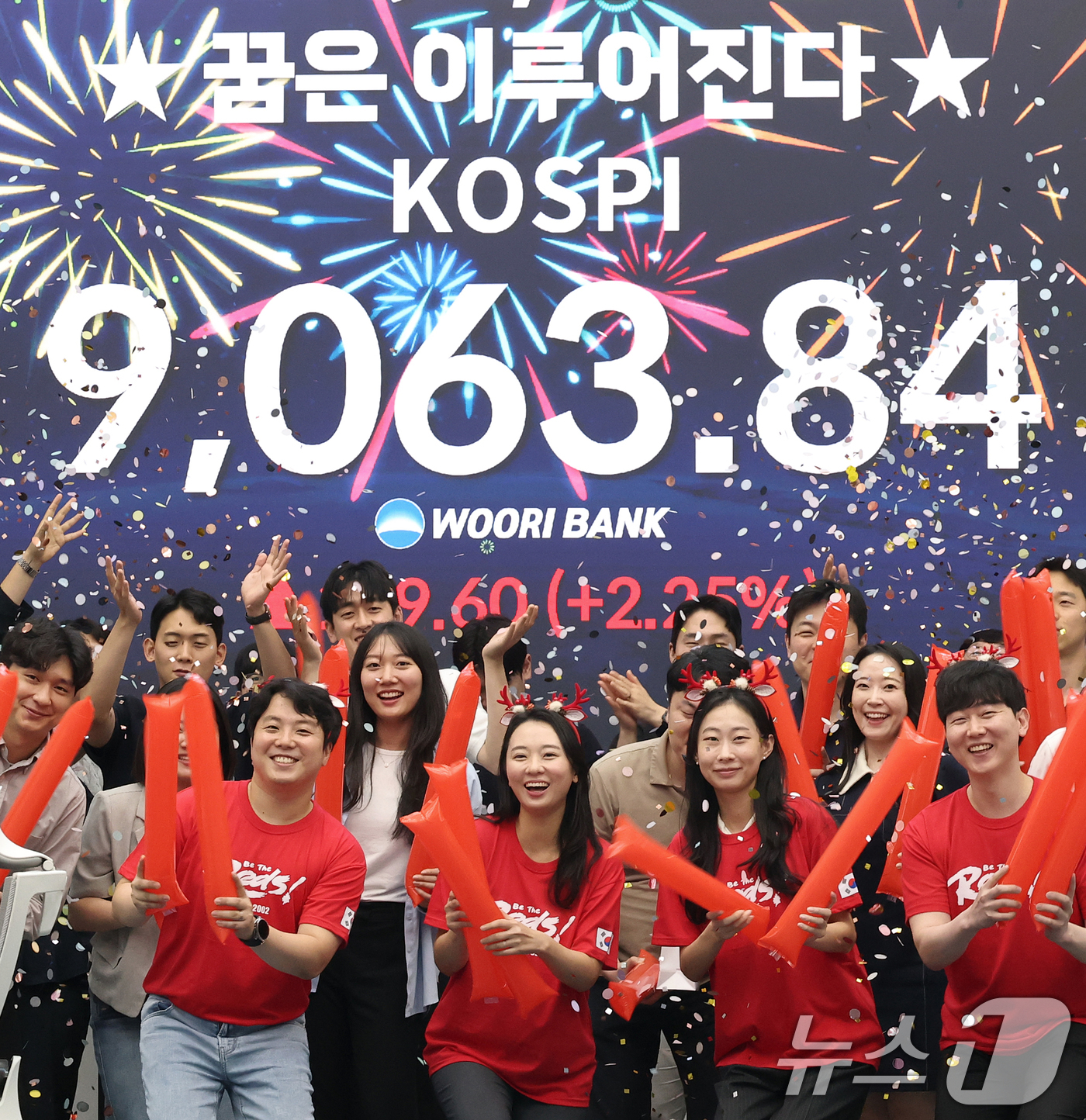 (서울=뉴스1) 오대일 기자 = 코스피 지수가 전인미답의 9000선 고지를 돌파한 18일 오후 서울 중구 우리은행 본점 딜링룸에서 직원들이 코스피 종가를 배경으로 축하 세리머니를 …