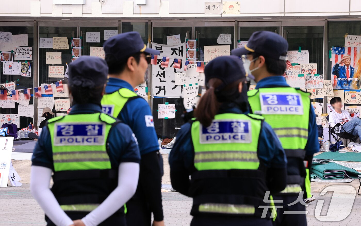 본문 이미지 - 제9회 전국동시지방선거 투표용지 부족 사태를 규탄하는 개표소 봉쇄 시위가 계속된 18일 서울 송파구 올림픽공원 핸드볼경기장 앞에 경찰들이 배치돼 있다. 2026.6.18 ⓒ 뉴스1 이호윤 기자