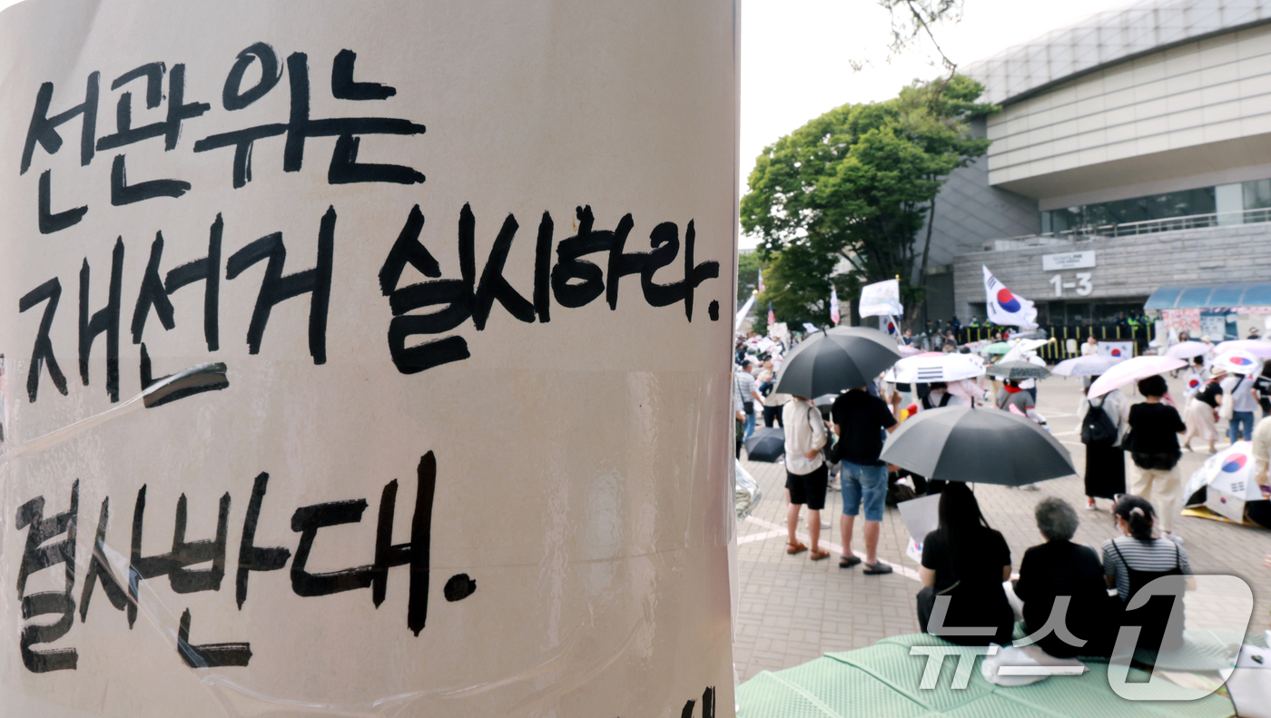 (서울=뉴스1) 이호윤 기자 = 제9회 전국동시지방선거 투표용지 부족 사태를 규탄하는 개표소 봉쇄 시위가 계속된 18일 서울 송파구 올림픽공원 핸드볼경기장 앞에서 시민들이 구호를 …