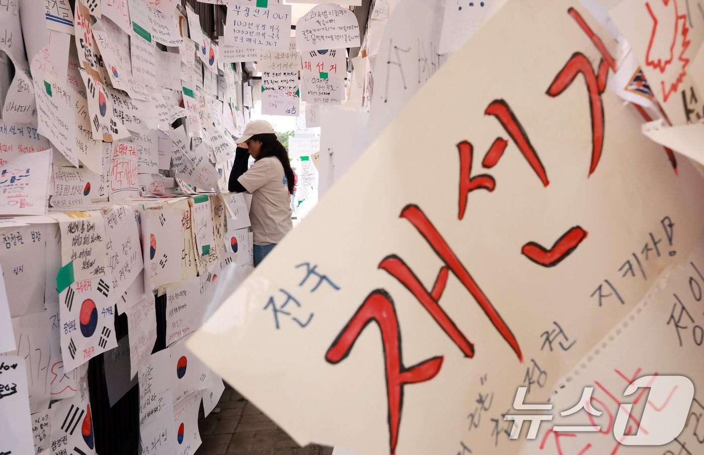(서울=뉴스1) 이호윤 기자 = 제9회 전국동시지방선거 투표용지 부족 사태를 규탄하는 개표소 봉쇄 시위가 계속된 18일 서울 송파구 올림픽공원 핸드볼경기장 티켓 부스에 재선거를 요 …