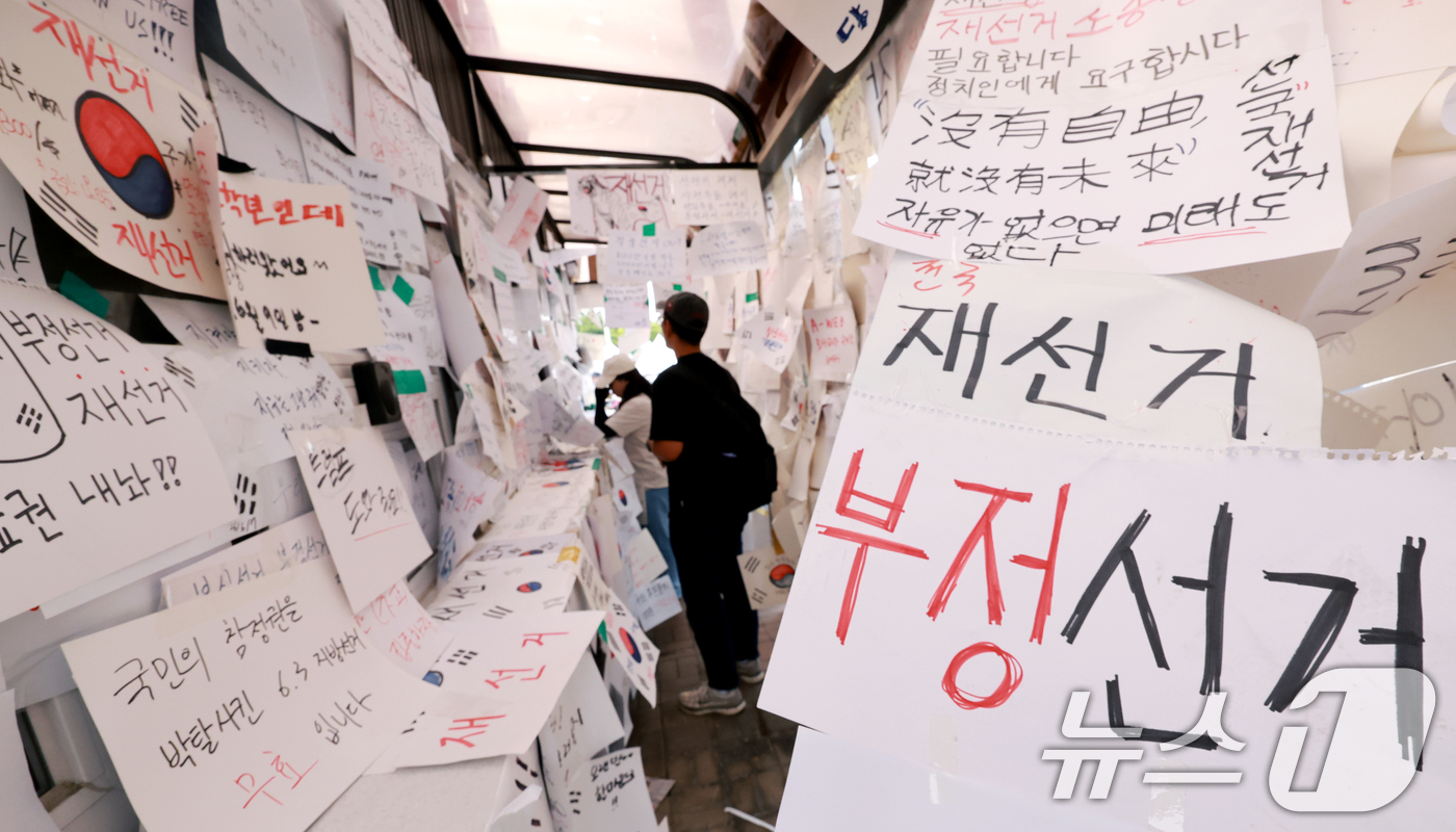 (서울=뉴스1) 이호윤 기자 = 제9회 전국동시지방선거 투표용지 부족 사태를 규탄하는 개표소 봉쇄 시위가 계속된 18일 서울 송파구 올림픽공원 핸드볼경기장 티켓 부스에 재선거를 요 …