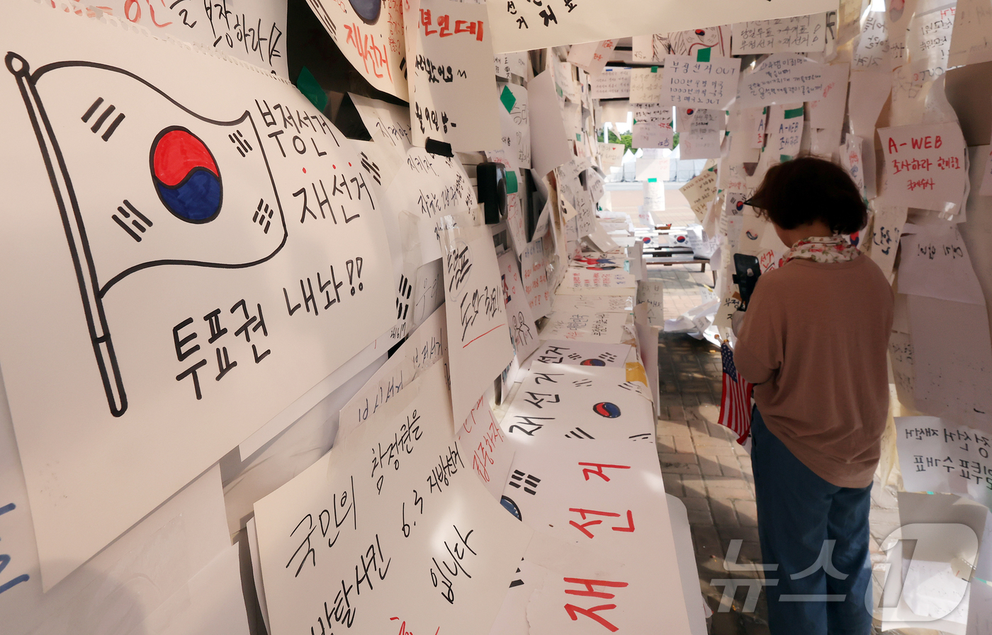 (서울=뉴스1) 김진환 기자 = 제9회 전국동시지방선거 투표용지 부족 사태를 규탄하는 개표소 봉쇄 시위가 계속된 19일 오전 서울 송파구 올림픽공원 핸드볼경기장 티켓 부스에 재선거 …