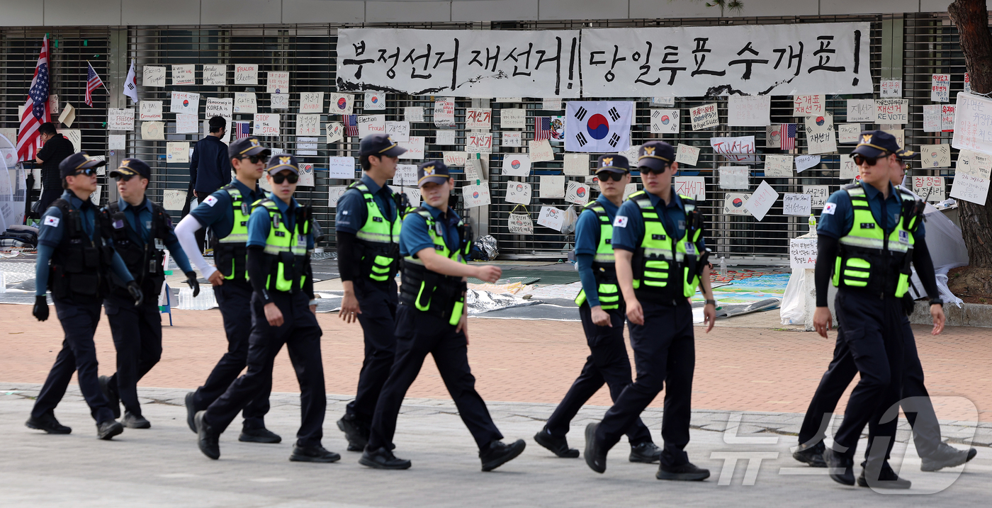 (서울=뉴스1) 김진환 기자 = 제9회 전국동시지방선거 투표용지 부족 사태를 규탄하는 개표소 봉쇄 시위가 계속된 19일 오전 서울 송파구 올림픽공원 핸드볼경기장 앞에 경찰들이 이동 …