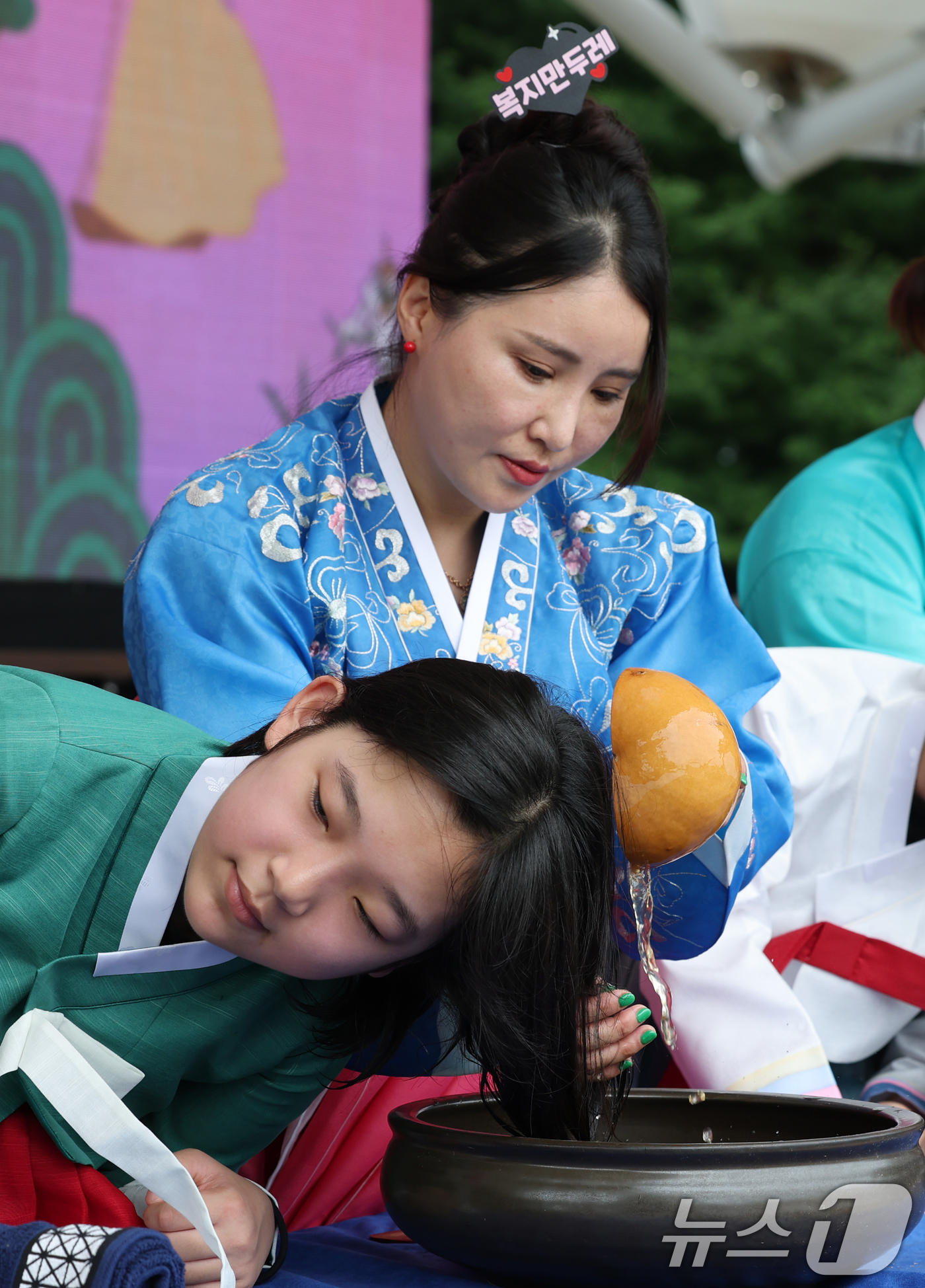 (대전=뉴스1) 김기태 기자 = 전통명절 단오(端午)날인 19일 대전 동구 판암근린공원에서 열린 판암골 단오한마당에서 학생들이 창포물 머리를 감고 있다. 2026.6.19/뉴스1