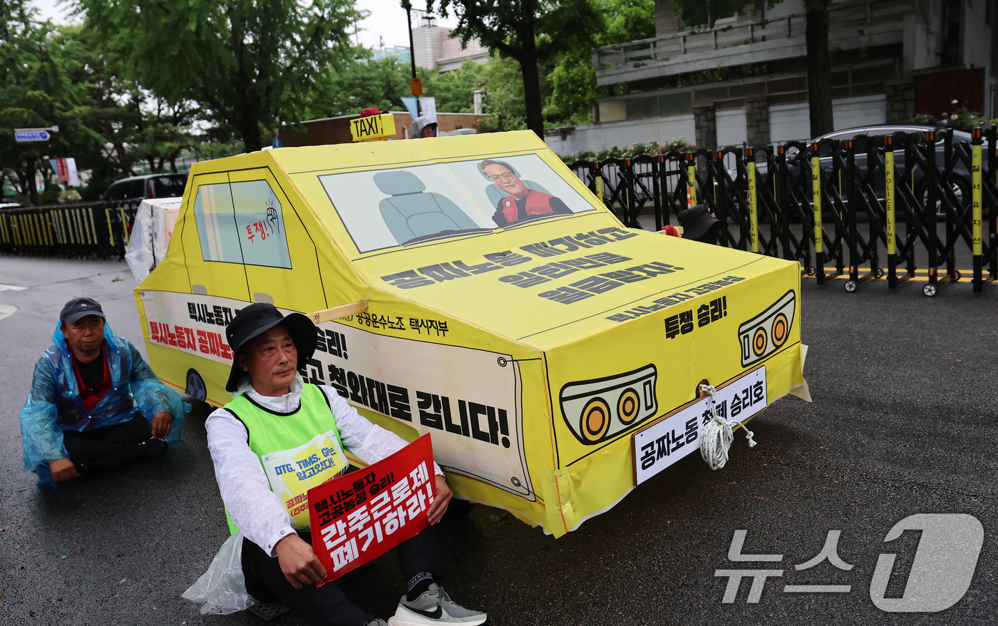 (서울=뉴스1) 오대일 기자 = 20일 오후 서울 종로구 청와대 사랑채 앞에서 열린 택시노동자 투쟁승리 공공운수노조 결의대회에서 참가자들이 '공짜노동 폐기'를 촉구하며 택시 모형을 …