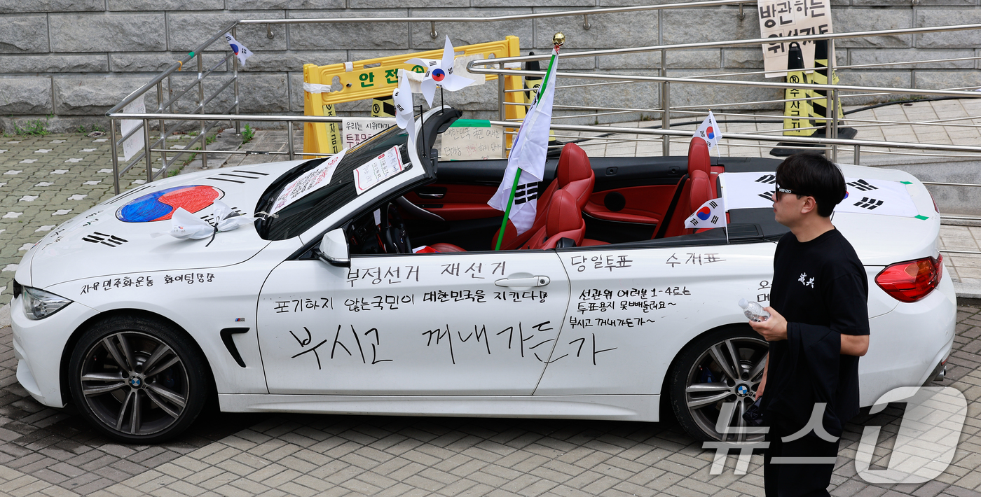 (서울=뉴스1) 안은나 기자 = 투표용지 부족 사태로 인한 시위가 17일째 이어지고 있는 21일 서울 송파구 올림픽공원 티켓링크 라이브 아레나(핸드볼경기장) 앞에 태극기와 선관위 …