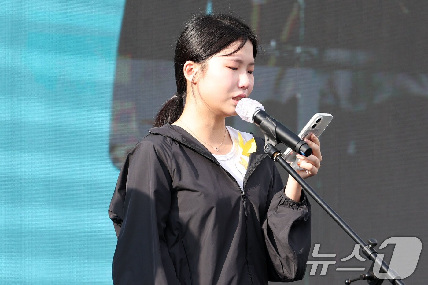 본문 이미지 - 21일 광주 광산구 신창동에 위치한 시민협치진흥원 주차장에서 열린 광주 여고생 흉기 사건 피해자인 고 이채원 양의 49재 추모제에서 이 양의 친구가 추모사를 하고 있다. 2026.6.21 ⓒ 뉴스1 이승현 기자