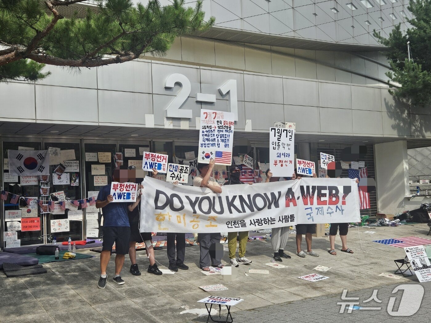 본문 이미지 - 22일 서울시 송파구 올림픽공원 핸드볼경기장을 봉쇄한 시위자들이 부정선거를 한국과 미국이 공조 수사해야 한다는 취지의 주장을 펴고 있다. 2026.06.22/ⓒ 뉴스1 윤지오 수습기자