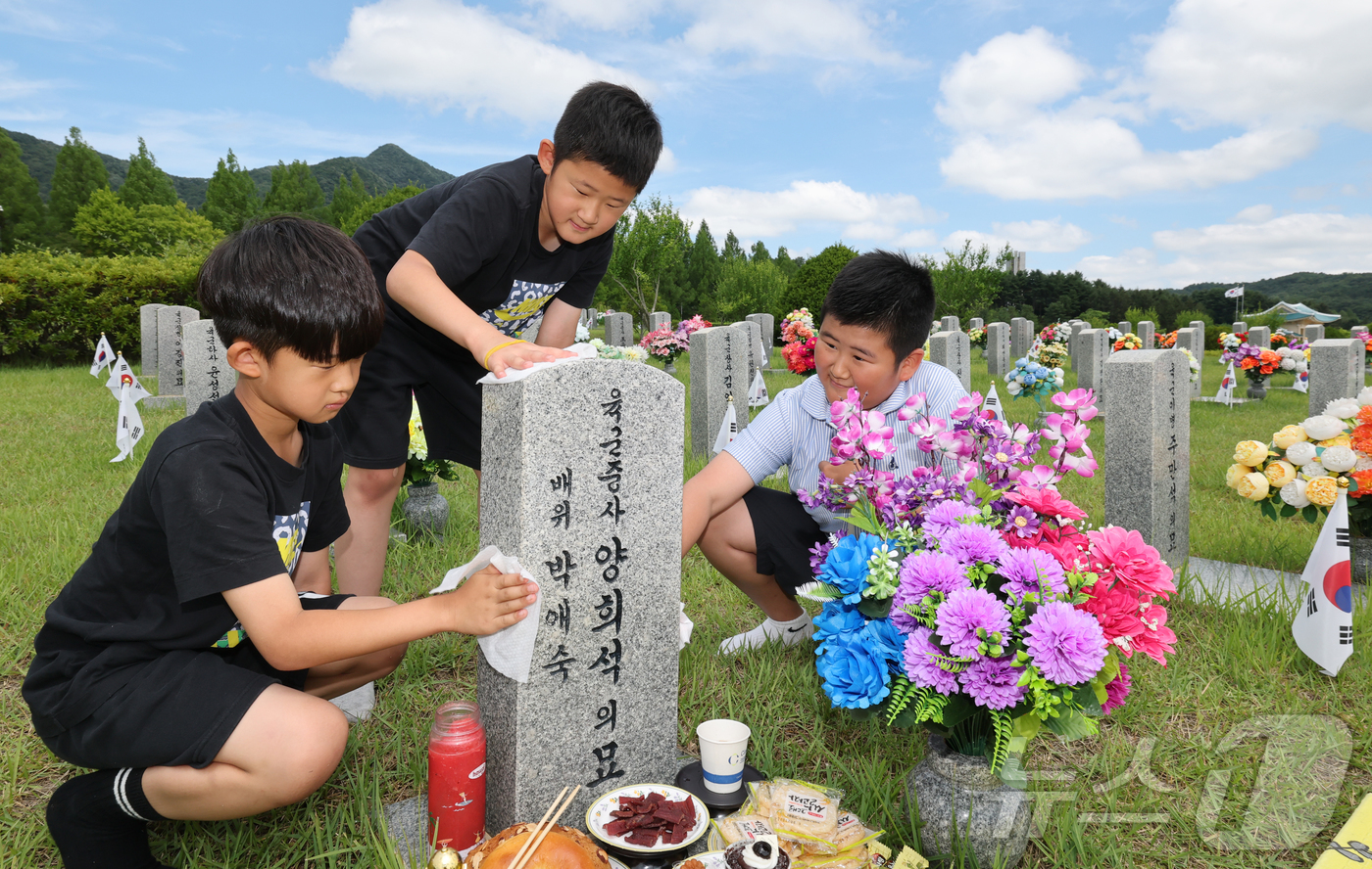 (대전=뉴스1) 김기태 기자 = 6·25 전쟁 76주년을 앞둔 23일 대전 유성구 국립대전현충원에서 유족이 묘비를 닦고 있다. 2026.6.23/뉴스1