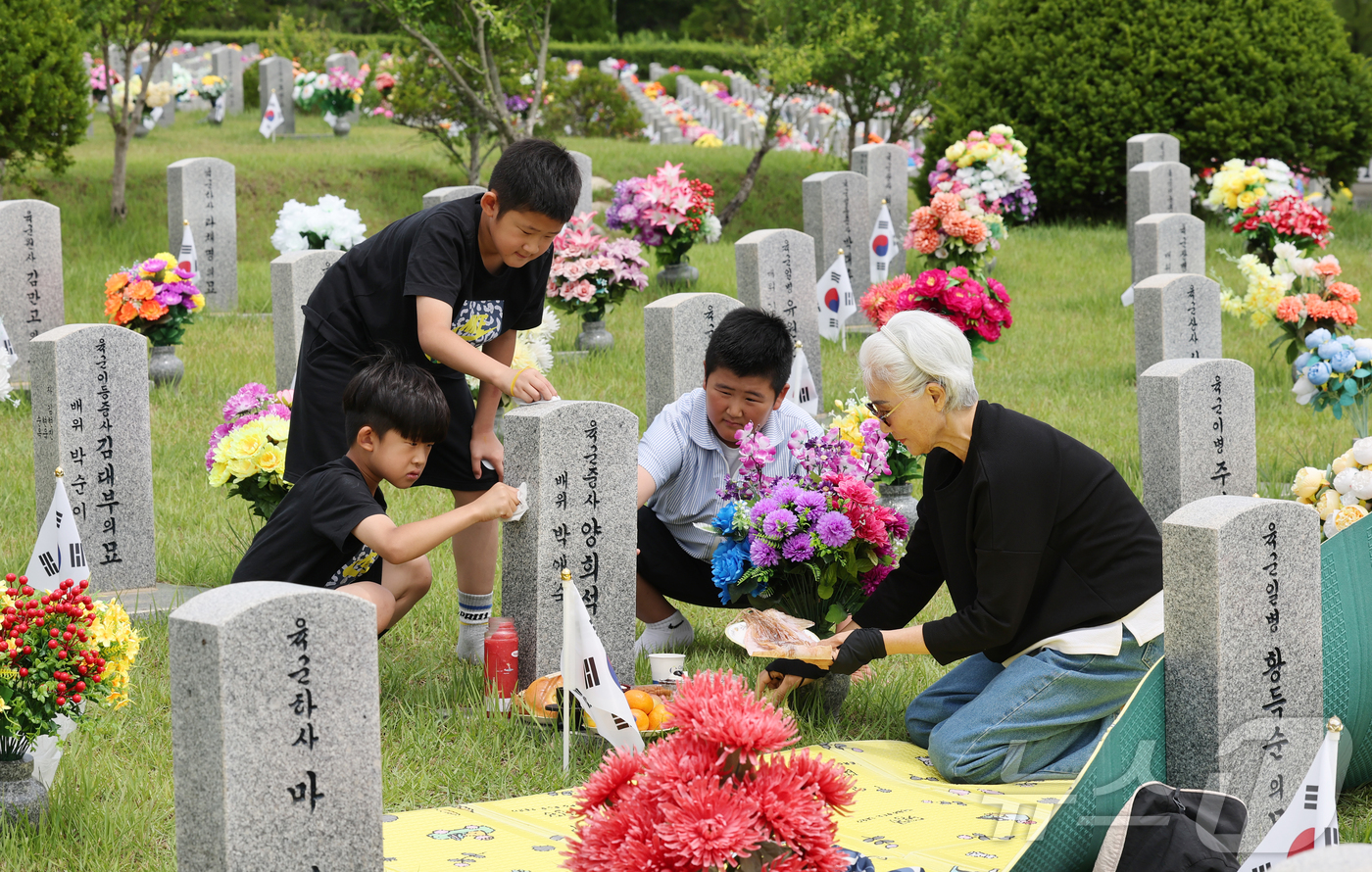 (대전=뉴스1) 김기태 기자 = 6·25 전쟁 76주년을 앞둔 23일 대전 유성구 국립대전현충원에서 유족이 참배 준비를 하고 있다. 2026.6.23/뉴스1