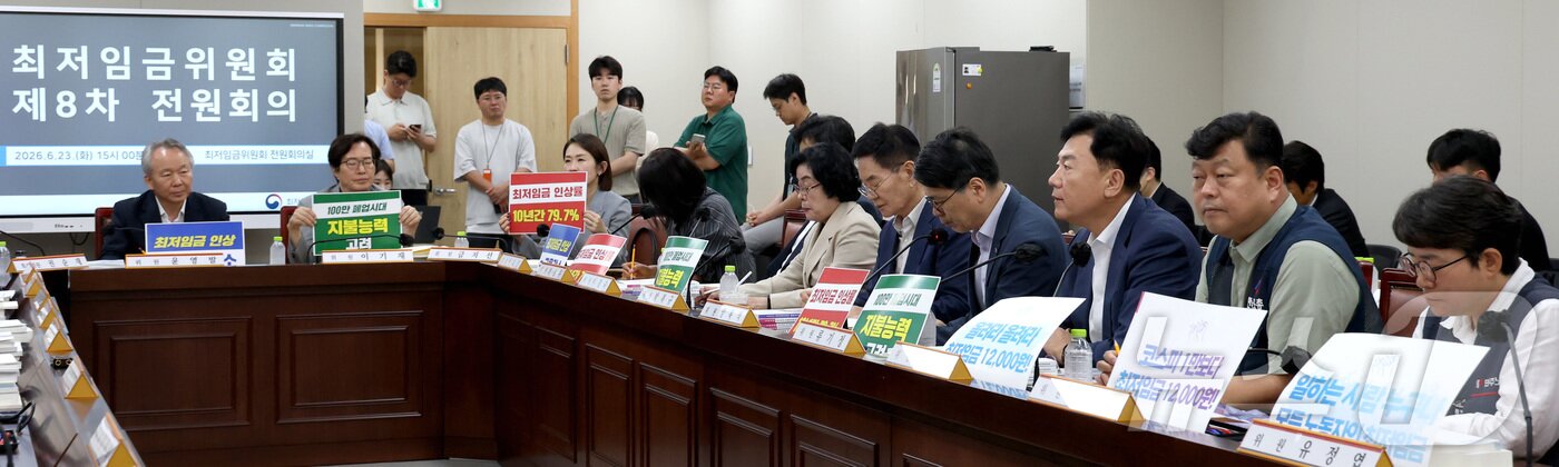 본문 이미지 - 지난 23일 세종시 정부세종청사 최저임금위원회에서 열린 2027년도 최저임금위원회 8차 전원회의에 참석한 사용자위원들과 근로자위원들이 손팻말을 들고 발언을 듣고 있다.ⓒ 뉴스1 김기남 기자
