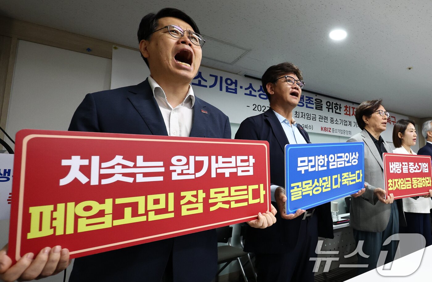 본문 이미지 - 이재광 중소기업중앙회 노동인력위원장을 비롯한 중소기업, 소상공인 대표들이 24일 오전 서울 영등포구 중소기업중앙회에서 열린 중소기업·소상공인 생존을 위한 최저임금 결정 촉구 기자회견에서 구호를 외치고 있다. 왼쪽부터 이중학 GS25 경영주협의회, 곽인학 한국금속패널공업협동조합 이사장, 이재광 중기중앙회 노동인력위원장, 윤영발 한국자동판매기운영협동조합 이사장, 금지선 한국메이크업미용사회 회장, 이기재 한국펫산업연합회, 김현 한국철근가공업협동조합, 양옥석 중소기업중앙회 인력정책본부장. 2026.6.24 ⓒ 뉴스1 최지환 기자