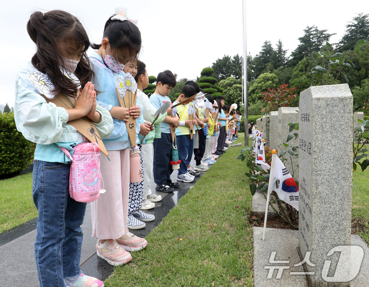 (부산=뉴스1) 윤일지 기자 = 제76주년 6·25 전쟁일을 하루 앞둔 24일 부산 남구 유엔기념공원을 찾은 엘지유치원 원생들이 직접 만든 종이 국화꽃을 들고 6·25 전쟁에 유엔 …