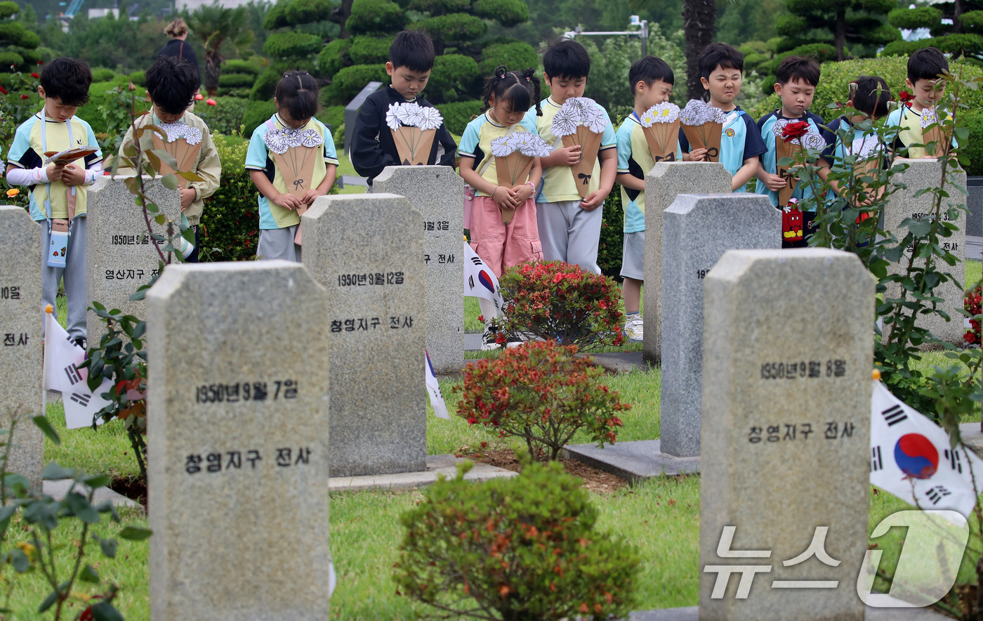 (부산=뉴스1) 윤일지 기자 = 제76주년 6·25 전쟁일을 하루 앞둔 24일 부산 남구 유엔기념공원을 찾은 엘지유치원 원생들이 직접 만든 종이 국화꽃을 들고 6·25 전쟁에 유엔 …