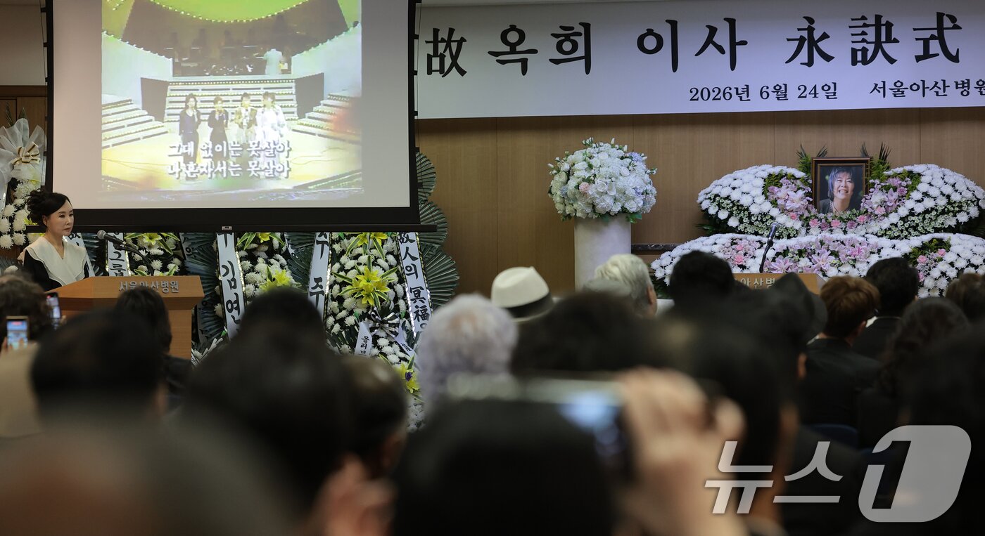 본문 이미지 - 24일 오전 서울 송파구 서울아산병원 장례식장에서 엄수된 고 (故) 옥희(본명 김광숙)의 영결식에서 고인의 생전모습이 담긴 영상이 상영되고 있다. 옥희는 지난해 신장암 진단을 받은 이후 투병 생활을 이어오다 지난 20일 향년 72세를 일기로 별세했다. 오랜 치료 과정 동안 프로권투 챔피언인 남편 홍수환이 곁을 지키며 간호한 것으로 알려져 안타까움을 더하고 있다. 2026.6.24 ⓒ 뉴스1 권현진 기자