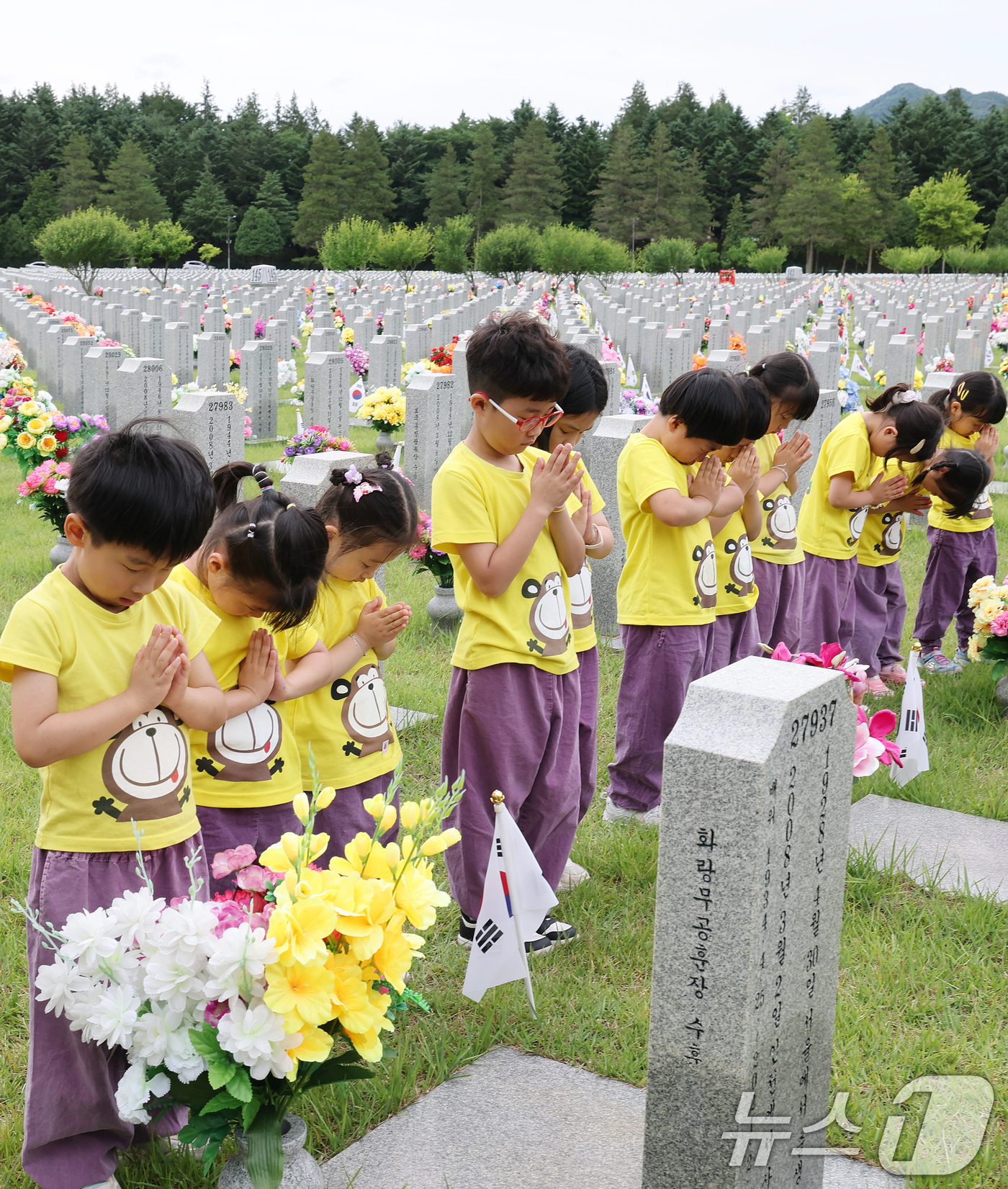 (대전=뉴스1) 김기태 기자 = 6·25 전쟁 76주년을 하루 앞둔 24일 대전 유성구 국립대전현충원 장병 1묘역에서 어린이집 원생들이 참배하고 있다. 2026.6.24/뉴스1