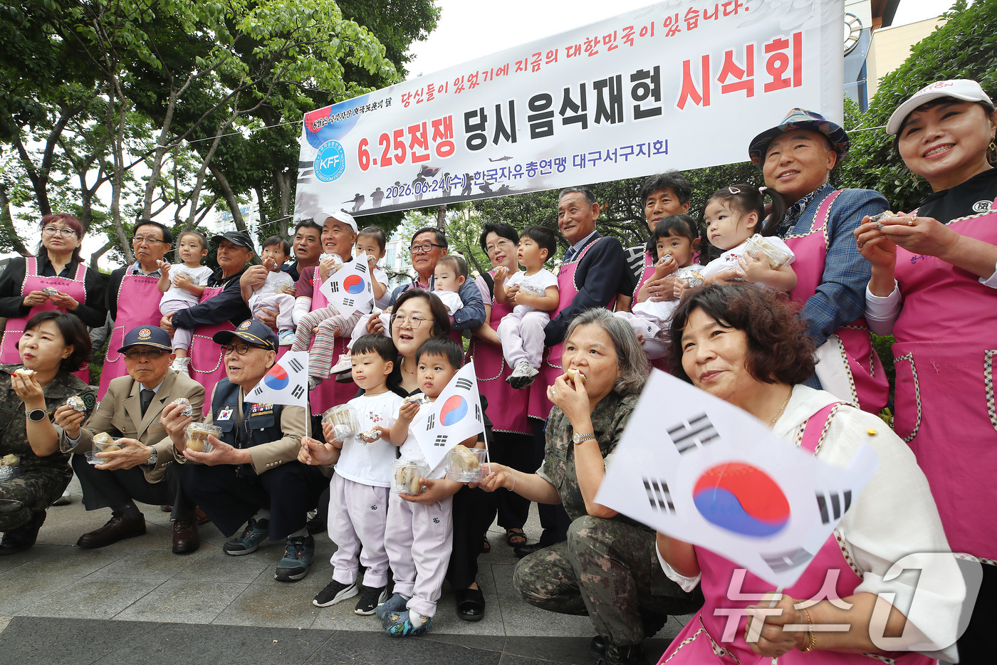 (대구=뉴스1) 공정식 기자 = 6·25전쟁 발발 76주기를 하루 앞둔 24일 대구 서구청 앞에서 열린 '6·25전쟁 당시 음식 시식회'를 찾은 어린이와 부모, 참전용사, 여성예비 …