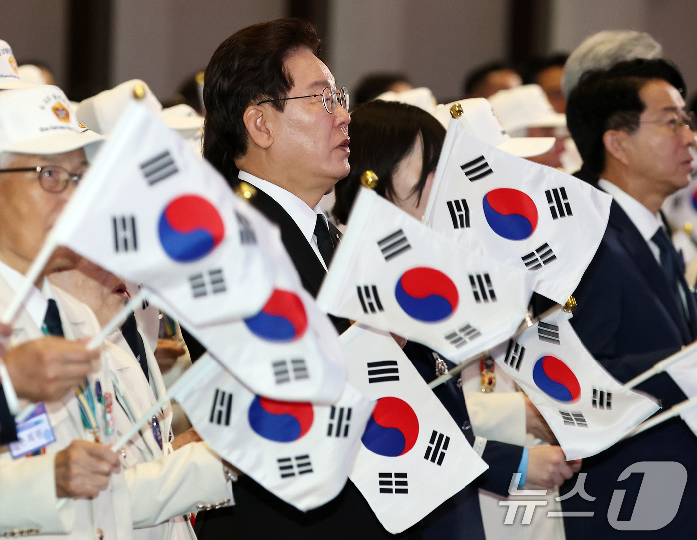 (수원=뉴스1) 허경 기자 = 이재명 대통령이 25일 경기 수원시 영통구 수원컨벤션센터에서 열린 6·25 전쟁 제76주년 기념식에서 태극기를 흔들며 6·25 기념 노래를 제창하고 …