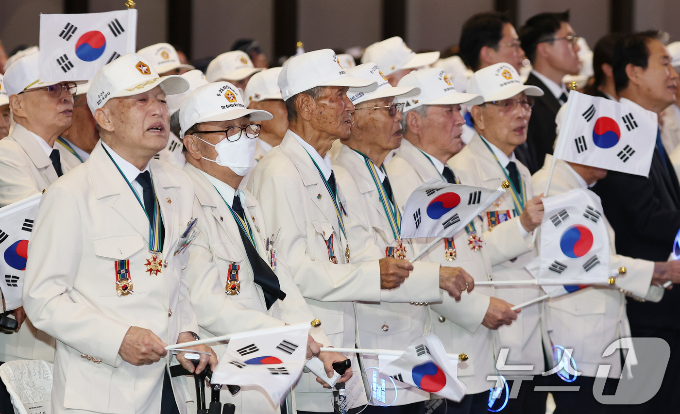 (수원=뉴스1) 허경 기자 = 25일 경기 수원시 영통구 수원컨벤션센터에서 열린 6·25 전쟁 제76주년 기념식에서 참전유공자들이 태극기를 흔들며 6·25 기념 노래를 제창하고 있 …