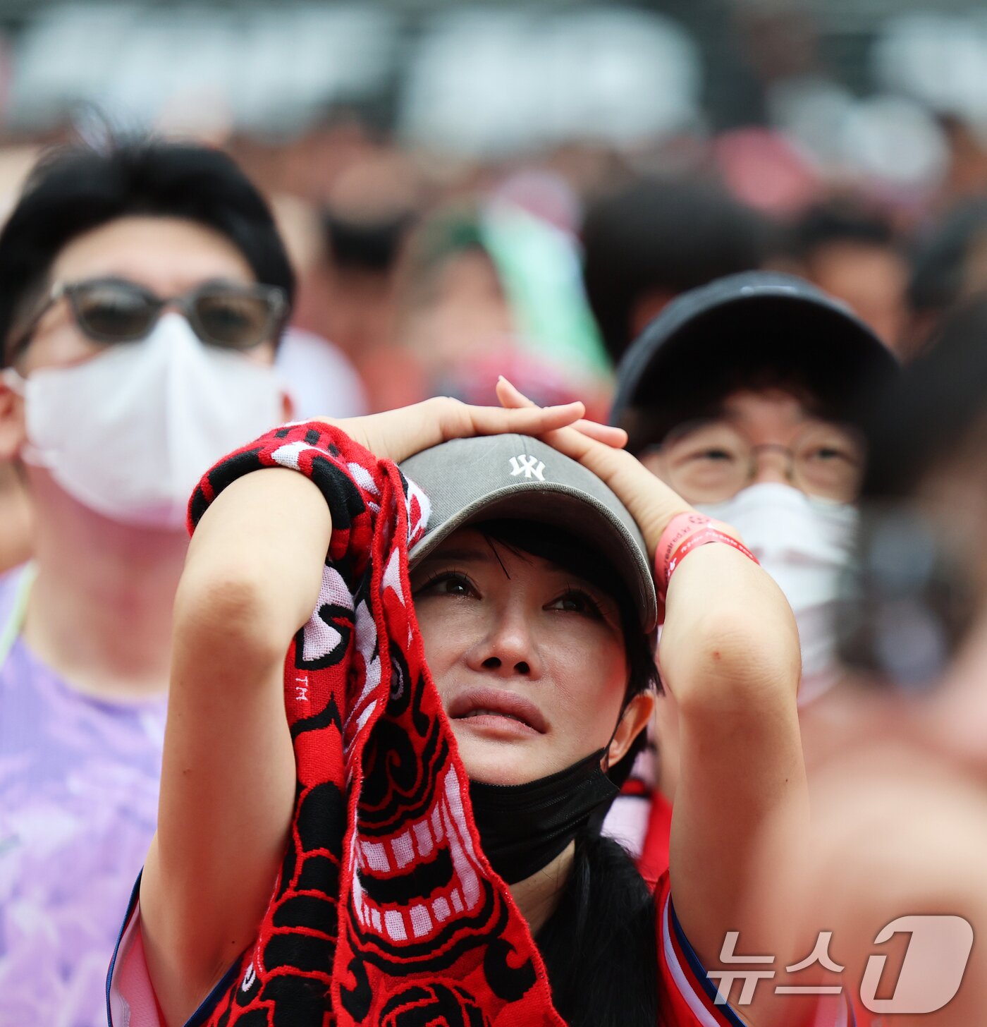 본문 이미지 - 축구 국가대표팀 공식 서포터즈 붉은악마가 25일 서울 종로구 광화문광장에서 열린 2026 국제축구연맹(FIFA) 북중미월드컵 A조 조별리그 3차전 대한민국과 남아프리카공화국의 경기 거리응원에서 0-1로 패하자 눈물을 글썽이고 있다. 2026.6.25 ⓒ 뉴스1 오대일 기자