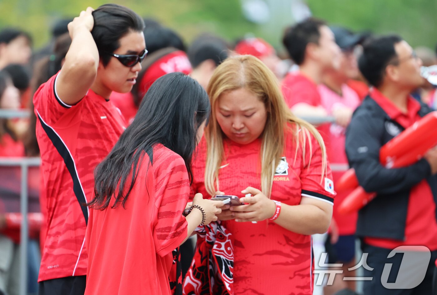 본문 이미지 - 축구 국가대표팀 공식 서포터즈 붉은악마와 시민들이 25일 서울 종로구 광화문광장에서 열린 2026 국제축구연맹(FIFA) 북중미월드컵 A조 조별리그 3차전 대한민국과 남아프리카공화국의 경기 거리응원에서 0-1로 패색이 짙어지자 스마트폰 화면을 바라보며 대화하고 있다. 2026.6.25 ⓒ 뉴스1 오대일 기자