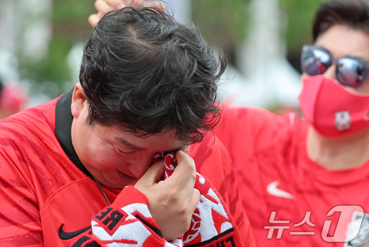 본문 이미지 - 축구 국가대표팀 공식 서포터즈 붉은악마가 25일 서울 종로구 광화문광장에서 열린 2026 국제축구연맹(FIFA) 북중미월드컵 A조 조별리그 3차전 대한민국과 남아프리카공화국의 경기 거리응원에서 0-1로 패하자 눈물을 흘리고 있다. ⓒ 뉴스1 오대일 기자