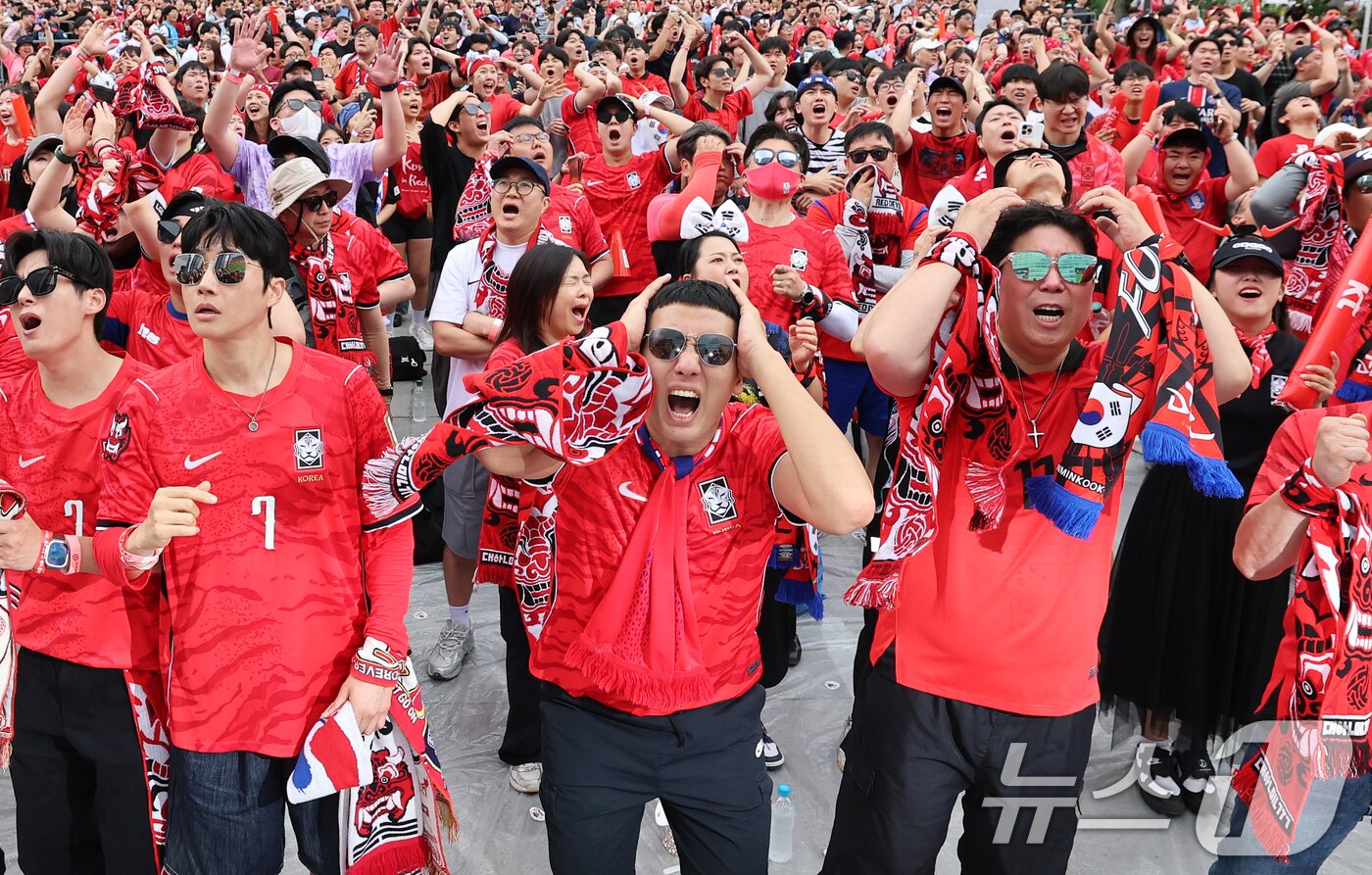 본문 이미지 - 축구 국가대표팀 공식 서포터즈 붉은악마와 시민들이 25일 서울 종로구 광화문광장에서 열린 2026 국제축구연맹(FIFA) 북중미월드컵 A조 조별리그 3차전 대한민국과 남아프리카공화국의 경기 거리응원에서 머리를 감싸고 있다. 2026.6.25 ⓒ 뉴스1 오대일 기자