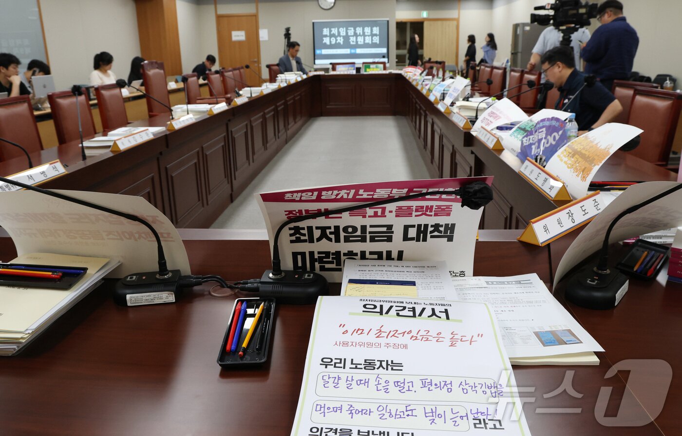 본문 이미지 - 지난 25일 세종시 정부세종청사 최저임금위원회에서 열린 2027년도 최저임금위원회 9차 전원회의에 참석한 근로자위원석에 각 노동계에서 보낸 의견서가 놓여 있다. 2026.6.25 ⓒ 뉴스1 김기남 기자