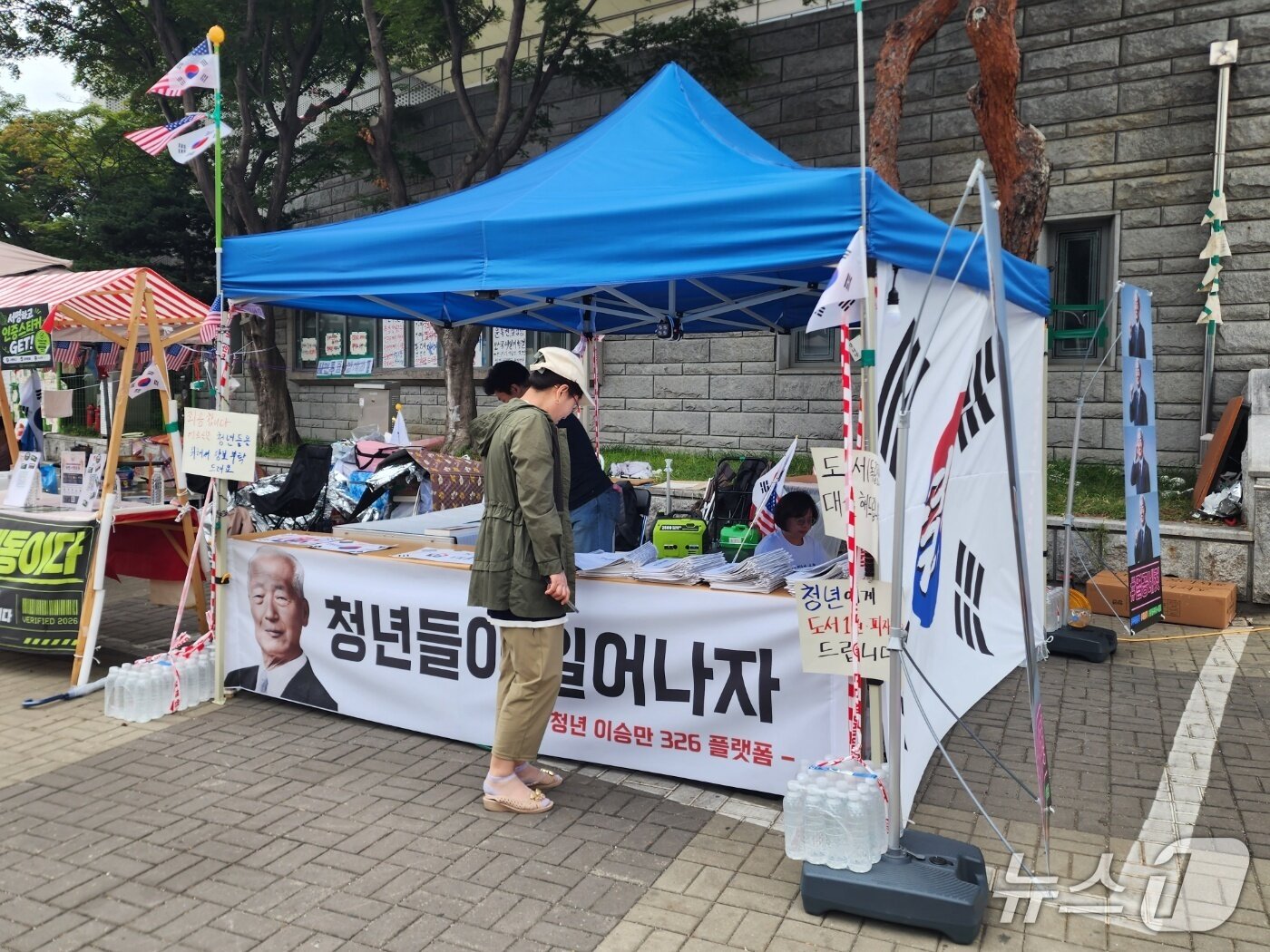 본문 이미지 - 25일 서울시 송파구 올림픽공원 핸드볼경기장 1-3게이트 왼편에 이승만 전 대통령 관련 부스가 설치돼 있다. 해당 부스에서는 '독립정신에 나타난 청년 이승만의 세계관'이라는 공보물을 배부하고 있다. 2026.06.25/ⓒ 뉴스1 권진영 기자