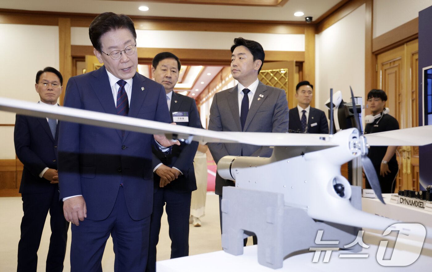 본문 이미지 - 이재명 대통령이 26일 청와대에서 열린 미래 新안보 혁신기업 육성 전략회의에 참석하며 정찰용 무인항공기를 살펴보고 있다. 2026.6.26 ⓒ 뉴스1 이재명 기자