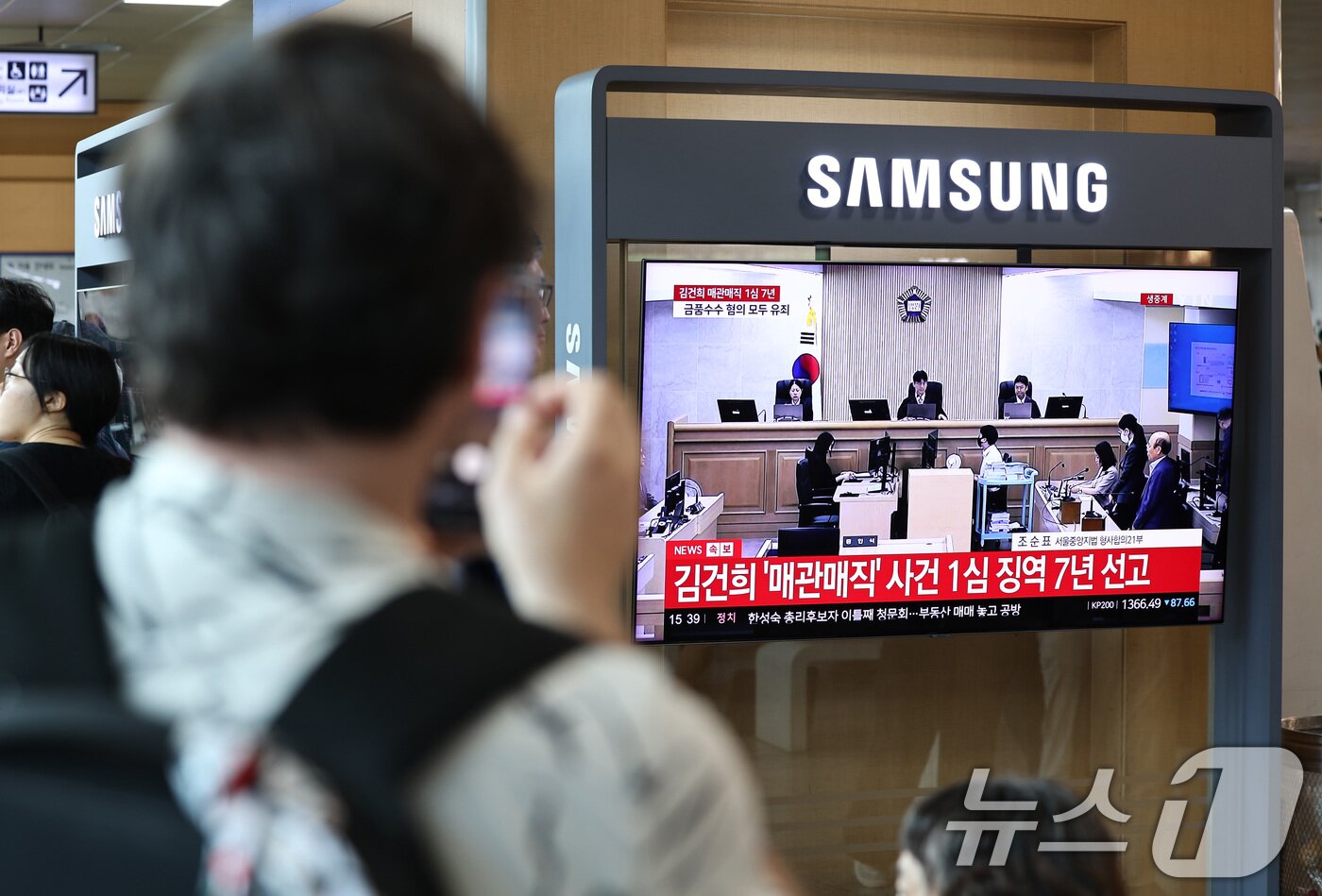 본문 이미지 - 26일 오후 서울 용산구 서울역 대합실에서 각종 고가 귀금속과 함께 인사, 이권 청탁을 받은 혐의로 특정범죄 가중처벌법상 알선수재 혐의로 기소된 김건희 여사의 1심 선고 생중계가 나오고 있다.  2026.6.26 ⓒ 뉴스1 최지환 기자