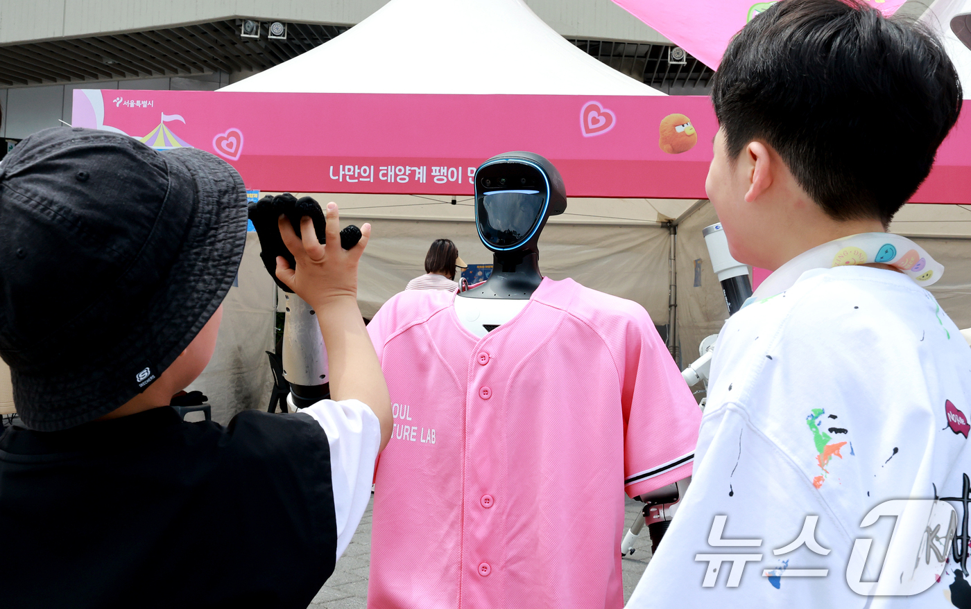 (서울=뉴스1) 이호윤 기자 = 27일 서울 강서구 마곡광장에서 열린 '제4회 서울퓨처랩 축제: 미래기술 놀이터'를 찾은 어린이들이 휴머노이드 로봇과 인사를 나누고 있다.  202 …