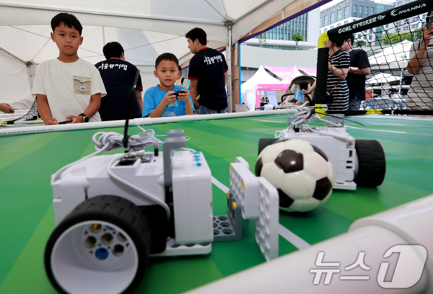 (서울=뉴스1) 이호윤 기자 = 27일 서울 강서구 마곡광장에서 열린 '제4회 서울퓨처랩 축제: 미래기술 놀이터'를 찾은 어린이들이 로봇 축구를 체험하고 있다. 2026.6.27/ …