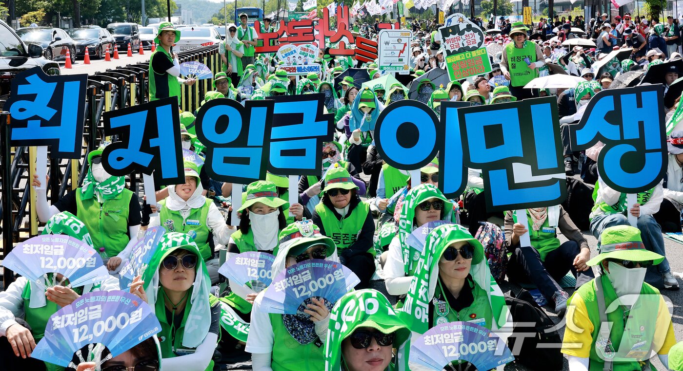 본문 이미지 - 27일 서울 종로구 송현광장 앞에서 열린 민주노총 비정규직 노동자 결의대회에서 참석자들이 '최저임금 확대적용 및 원청교섭·노정교섭 쟁취' 등을 촉구하고 있다. 2026.6.27 ⓒ 뉴스1 이호윤 기자