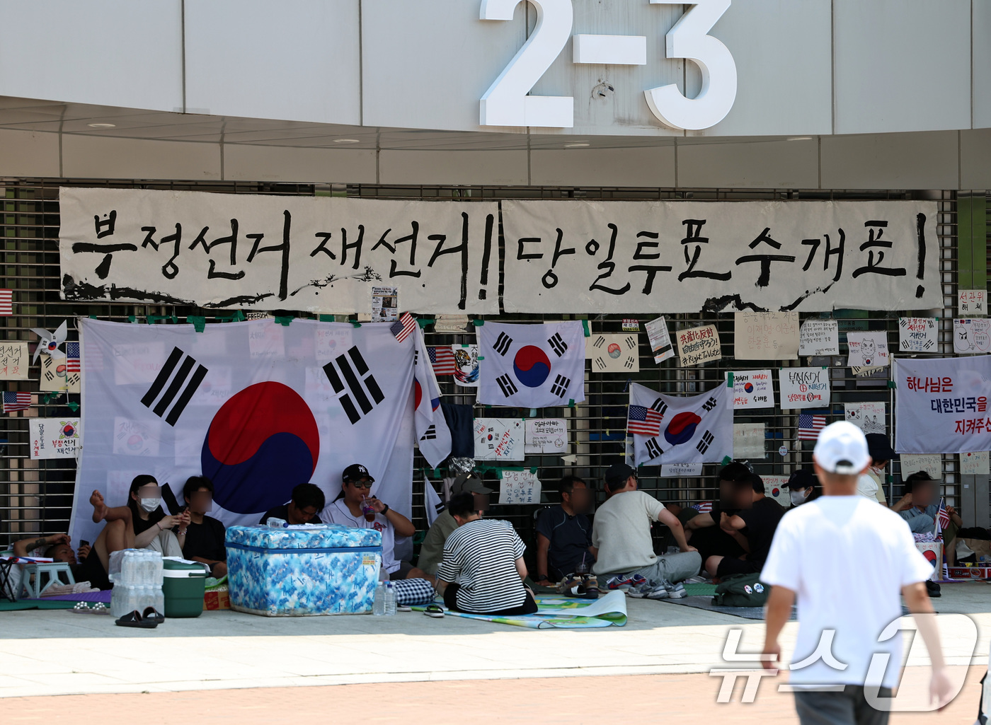 (서울=뉴스1) 구윤성 기자 = 6·3 지방선거 투표용지 부족사태로 인한 '잠실 봉쇄시위'가 25일째를 맞은 25일 서울 송파구 올림픽공원 핸드볼경기장에서 참가자들이 폭염을 피해 …