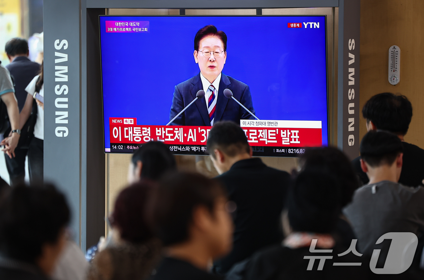 (서울=뉴스1) 김도우 기자 = 29일 서울역에서 시민들이 이재명 대통령이 주재하는 3대 메가프로젝트 국민보고회를 TV 생중계를 통해 시청하고 있다. 2026.6.29/뉴스1