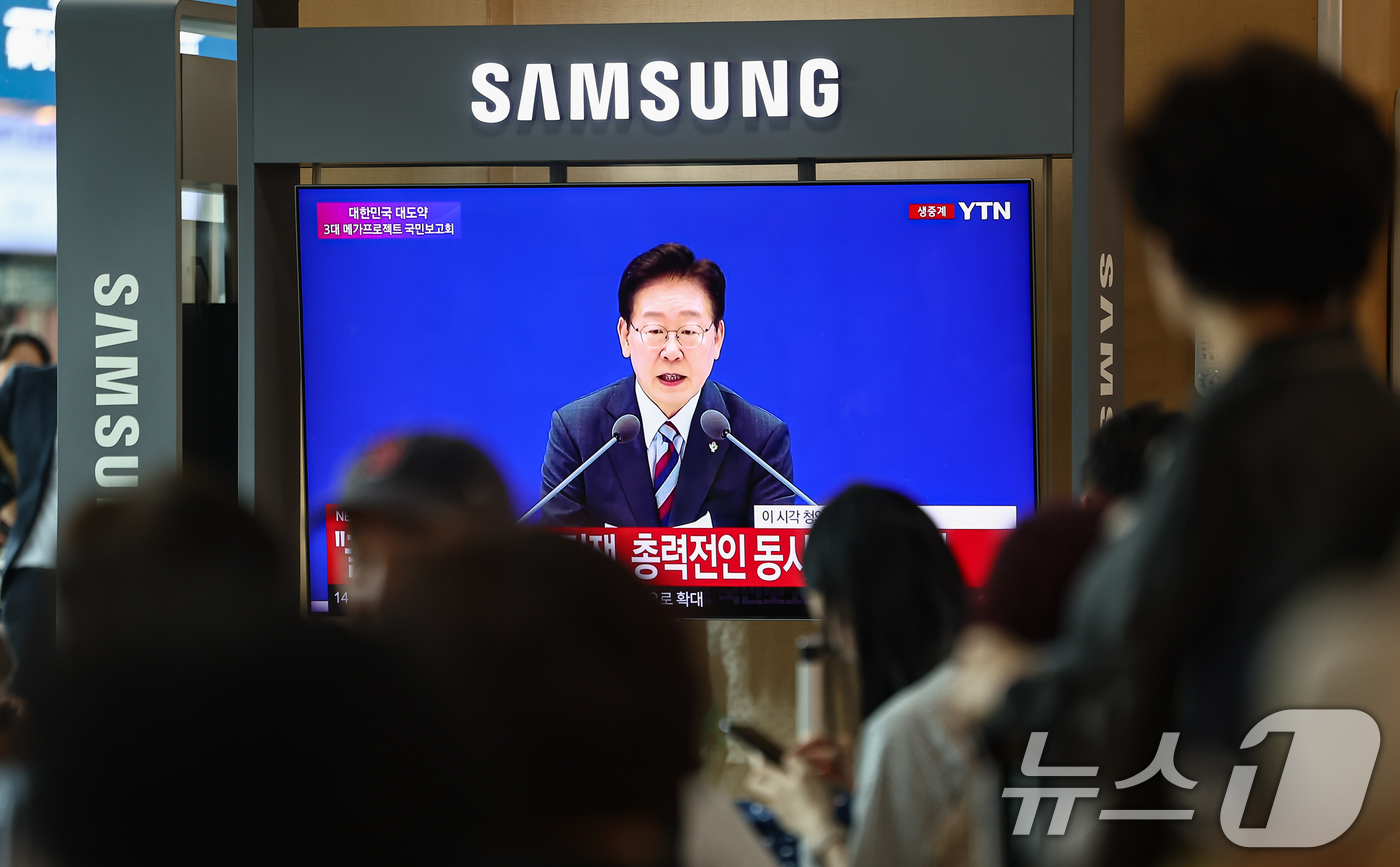 (서울=뉴스1) 김도우 기자 = 29일 서울역에서 시민들이 이재명 대통령이 주재하는 3대 메가프로젝트 국민보고회를 TV 생중계를 통해 시청하고 있다. 2026.6.29/뉴스1