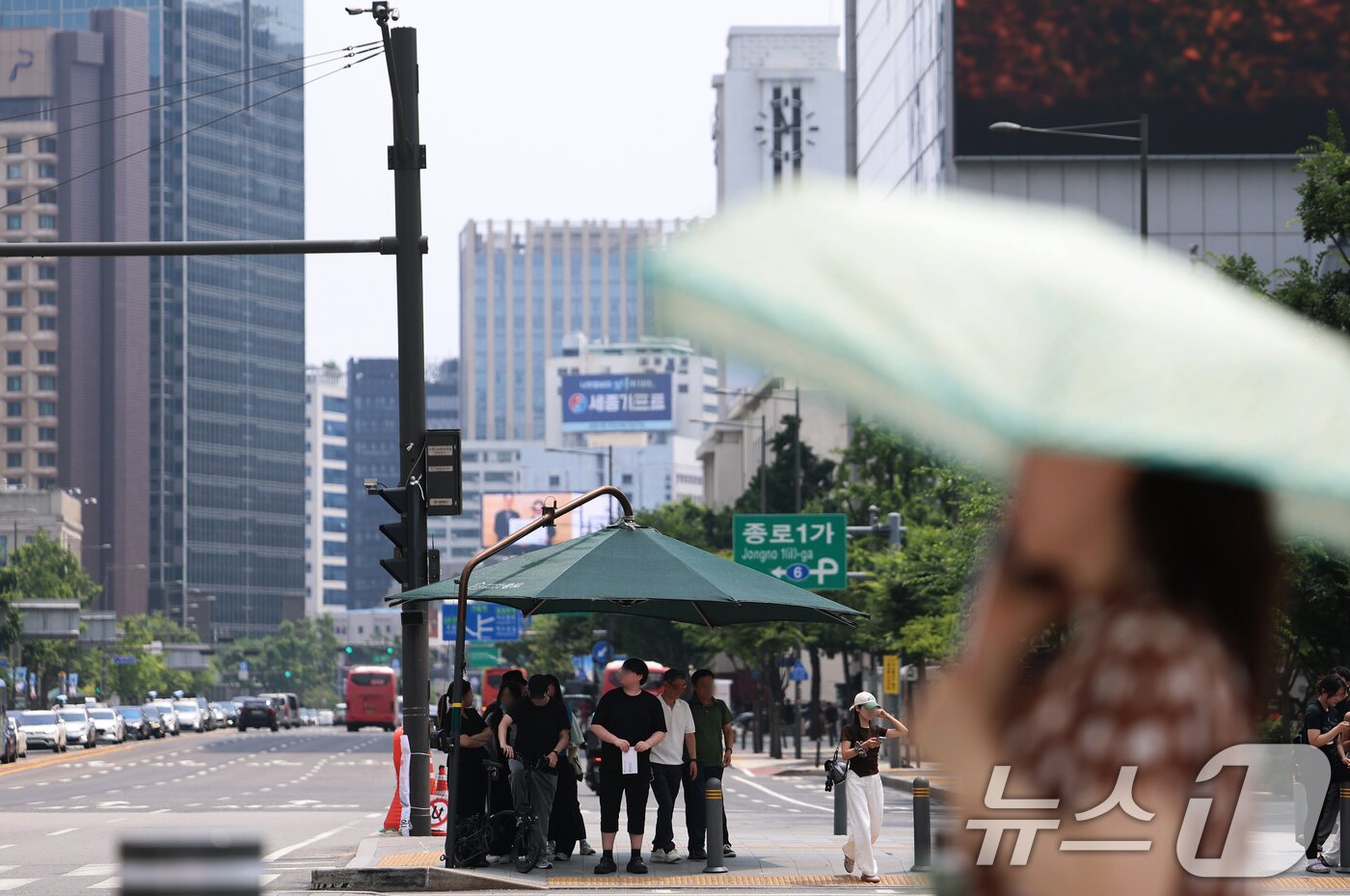 본문 이미지 - 서울 전역에 올해 첫 폭염주의보가 발표된 29일 오후 서울 종로구 광화문 네거리에서 시민들이 횡단보도 그늘막 아래에 모여 햇볕을 피하고 있다. 2026.6.29 ⓒ 뉴스1 오대일 기자