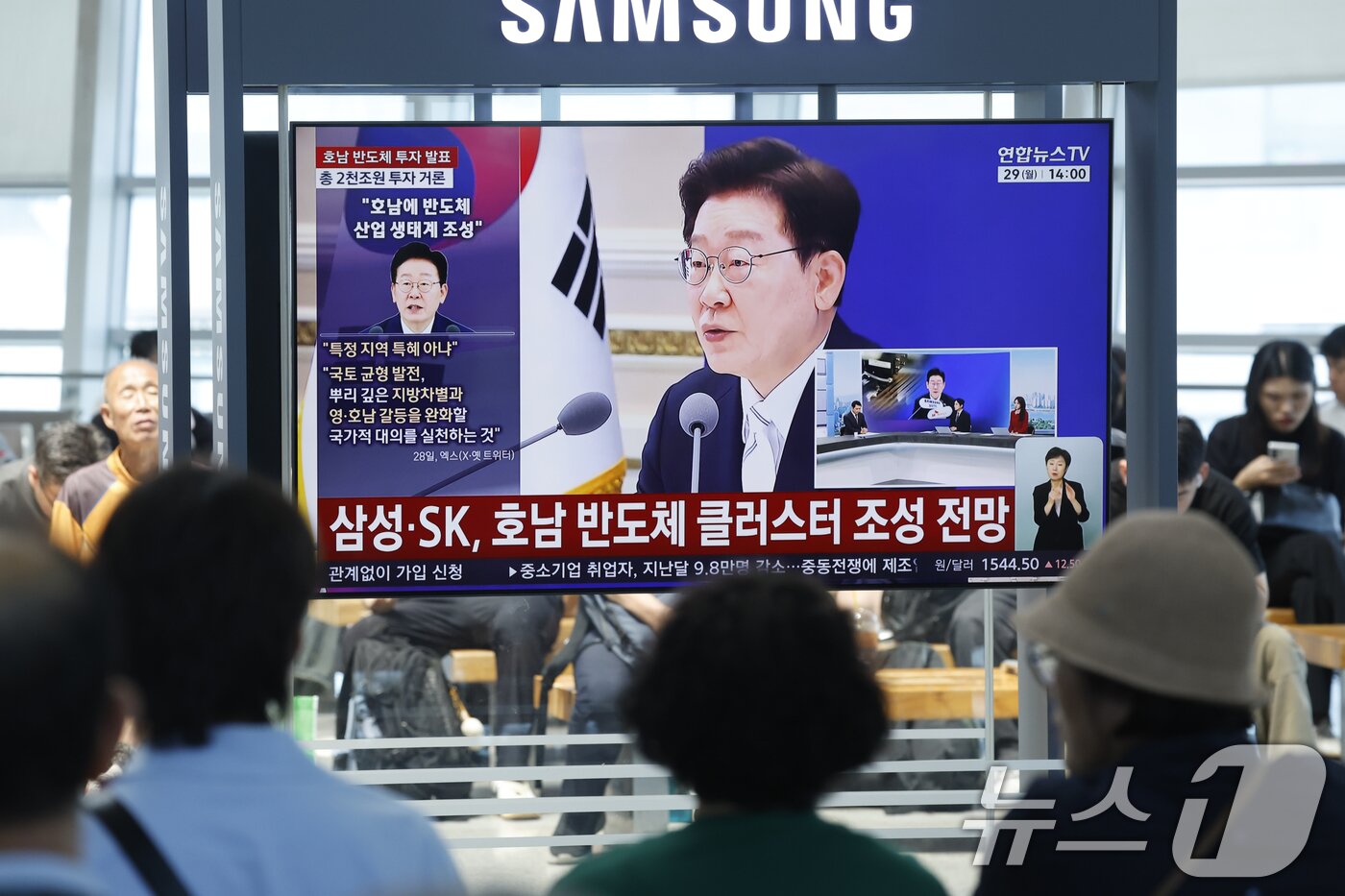 본문 이미지 - 광주 시민들이 29일 광주 KTX송정역에서 청와대 영빈관에서 열린 '대한민국 대도약 3대 메가프로젝트 국민보고회'의 이재명 대통령의 투자 발표 생중계 뉴스를 지켜보고 있다. 2026.6.29 ⓒ 뉴스1 김태성 기자