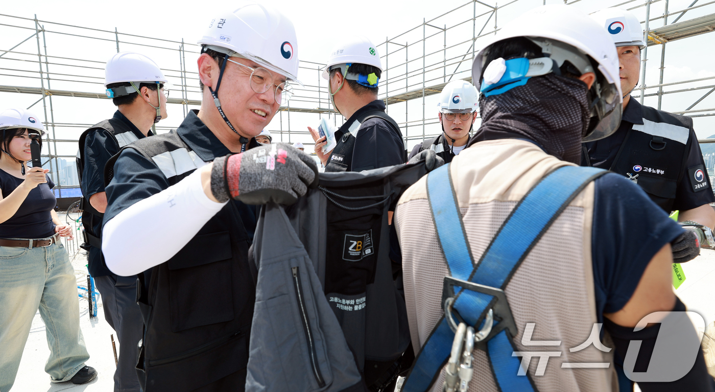 (서울=뉴스1) = 김영훈 고용노동부 장관이 29일 오후 대전의 한 대학교 기숙사 신축공사 현장을 불시 방문해 건설현장 노동자에게 냉감조끼를 입혀주고 있다. (고용부 제공. 재판매 …