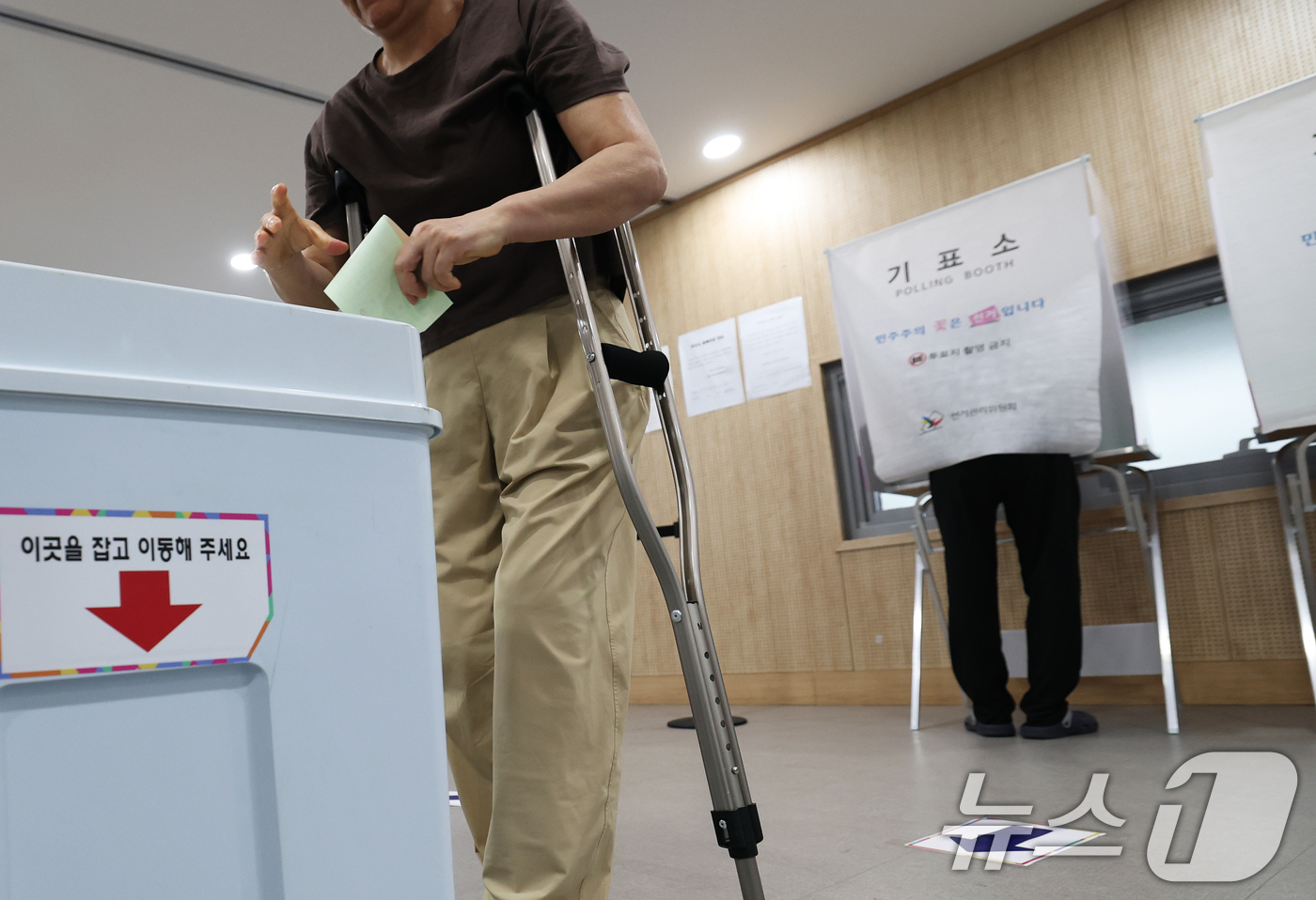 (서울=뉴스1) 오대일 기자 = 제9회 전국동시지방선거 및 국회의원 재·보궐 선거 시작된 3일 오전 서울 동작구 상도4동주민센터에 마련된 투표소에서 한 여성이 목발을 짚은 채 소중 …