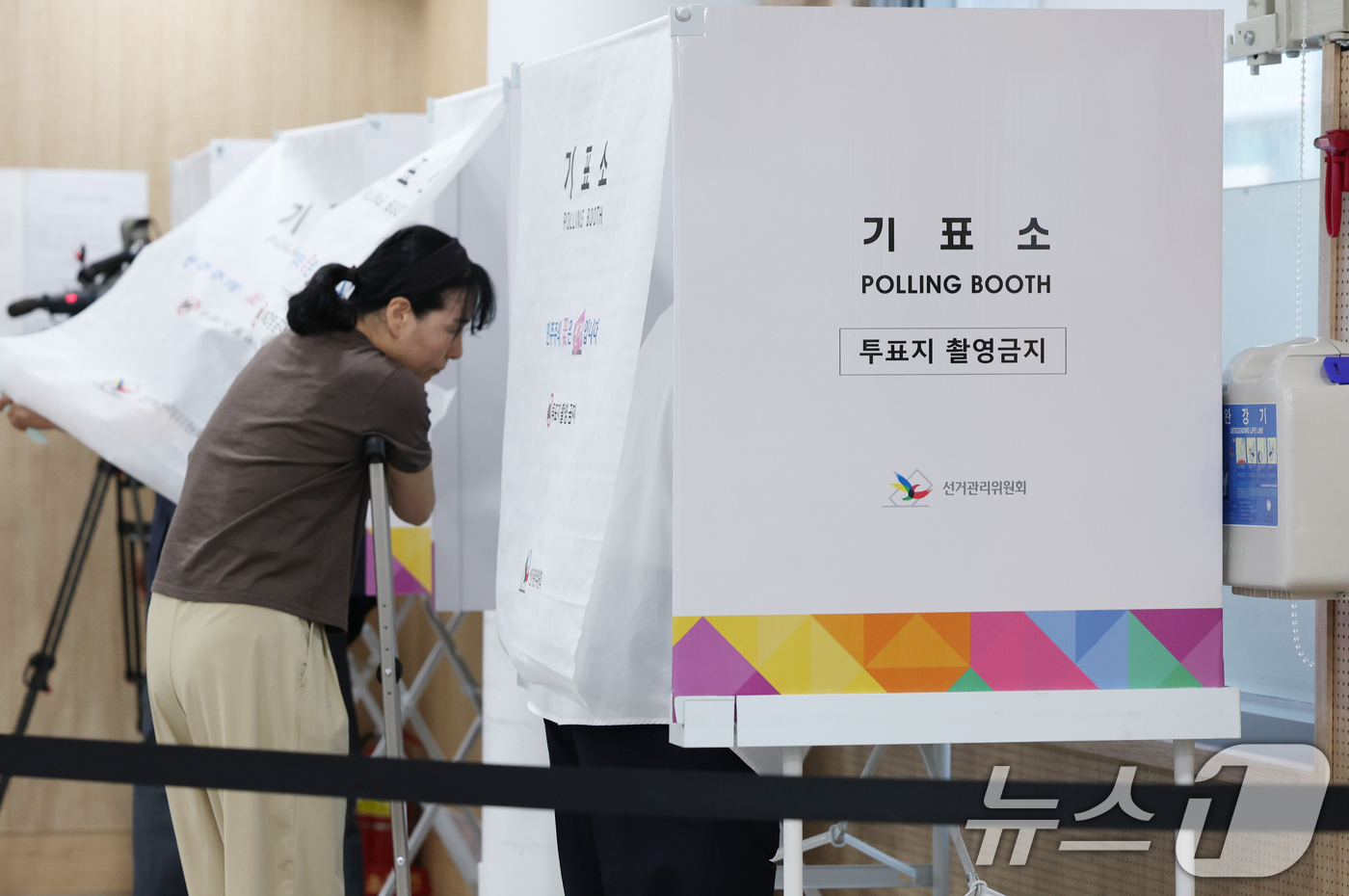 (서울=뉴스1) 오대일 기자 = 제9회 전국동시지방선거 및 국회의원 재·보궐 선거 시작된 3일 오전 서울 동작구 상도4동주민센터에 마련된 투표소에서 한 여성이 목발을 짚은 채 소중 …