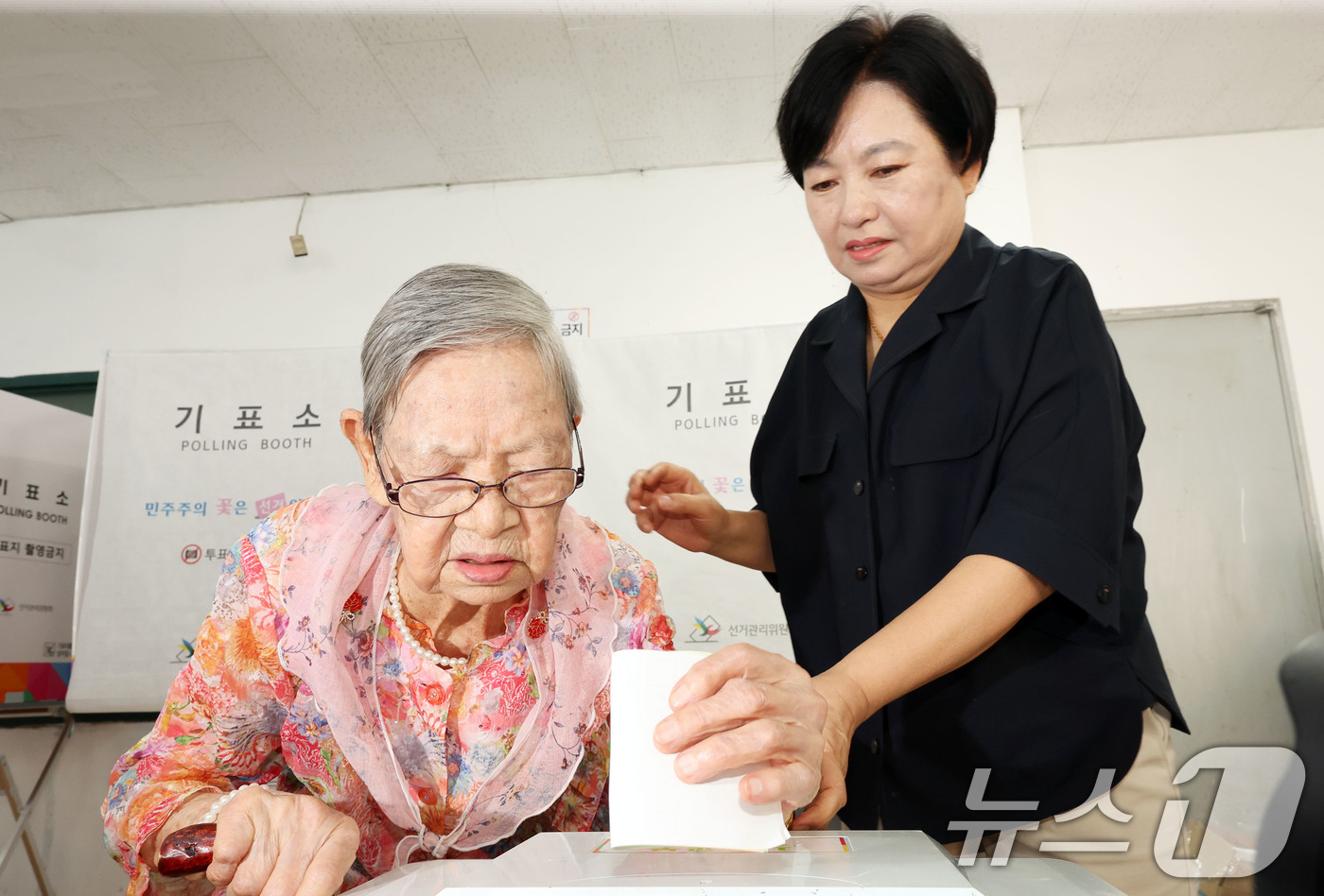 (광주=뉴스1) 박지현 기자 = 제9회 전국동시지방선거일인 3일 광주 동구 계림1동 2투표소에서 자치구 내 최고령 유권자인 110세 김정자 어르신이 투표함에 투표지를 넣고 있다. …