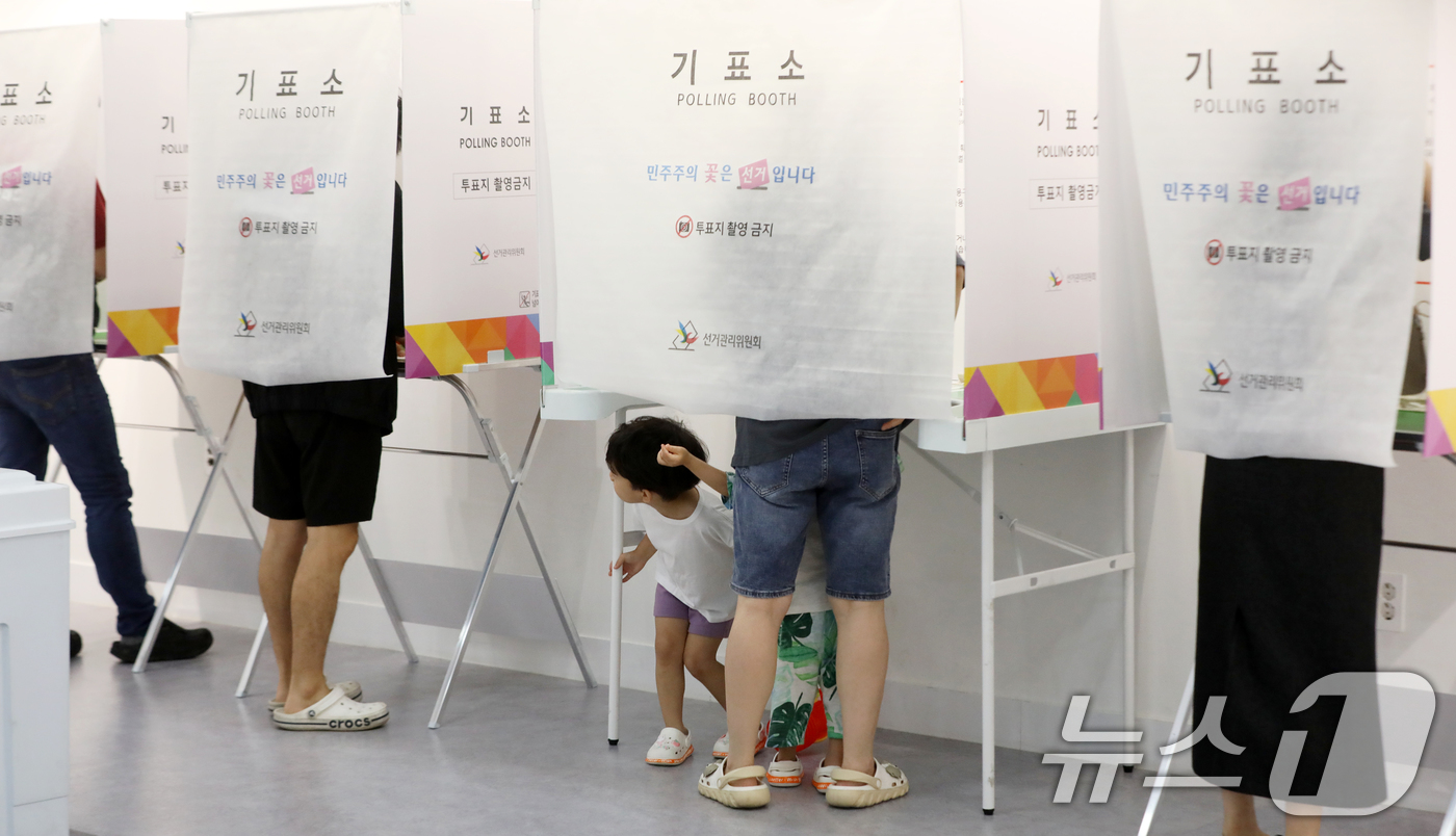 (부산=뉴스1) 윤일지 기자 = 제9회 전국동시지방선거 및 국회의원 재·보궐선거일인 3일 부산 부산진구청에 마련된 부암제1동제4투표소에서 엄마와 투표소를 찾은 아이들이 신기한 듯 …